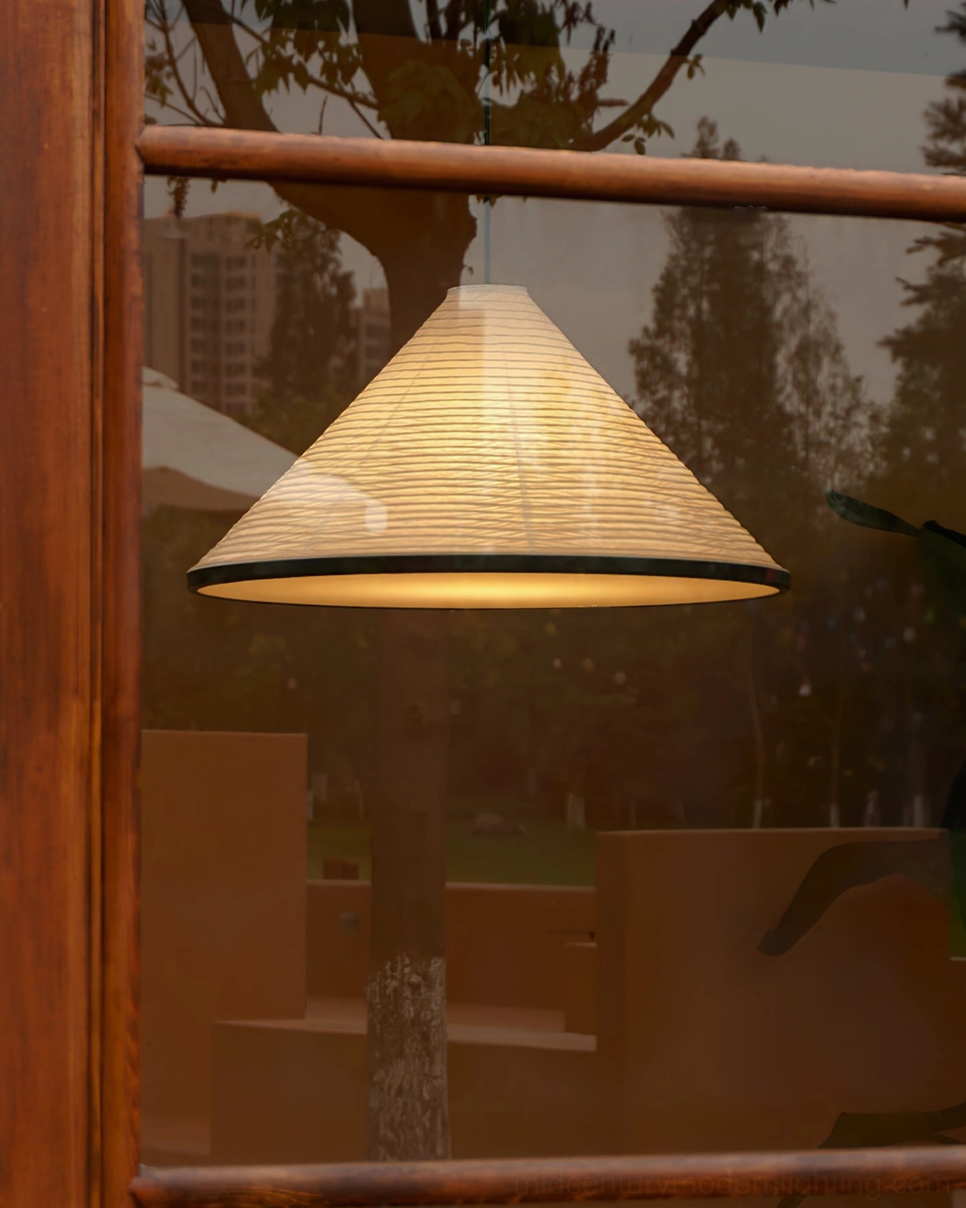 Illuminated Cone Washi Pendant Light viewed through wooden window frame glowing warm interior ambiance
