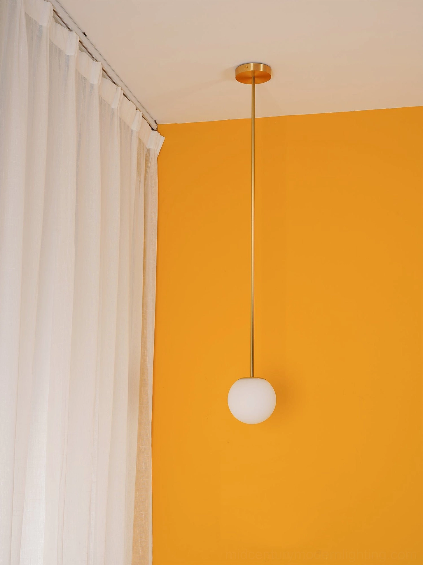 Contemporary brass globe pendant light with architectural minimalist design aesthetic