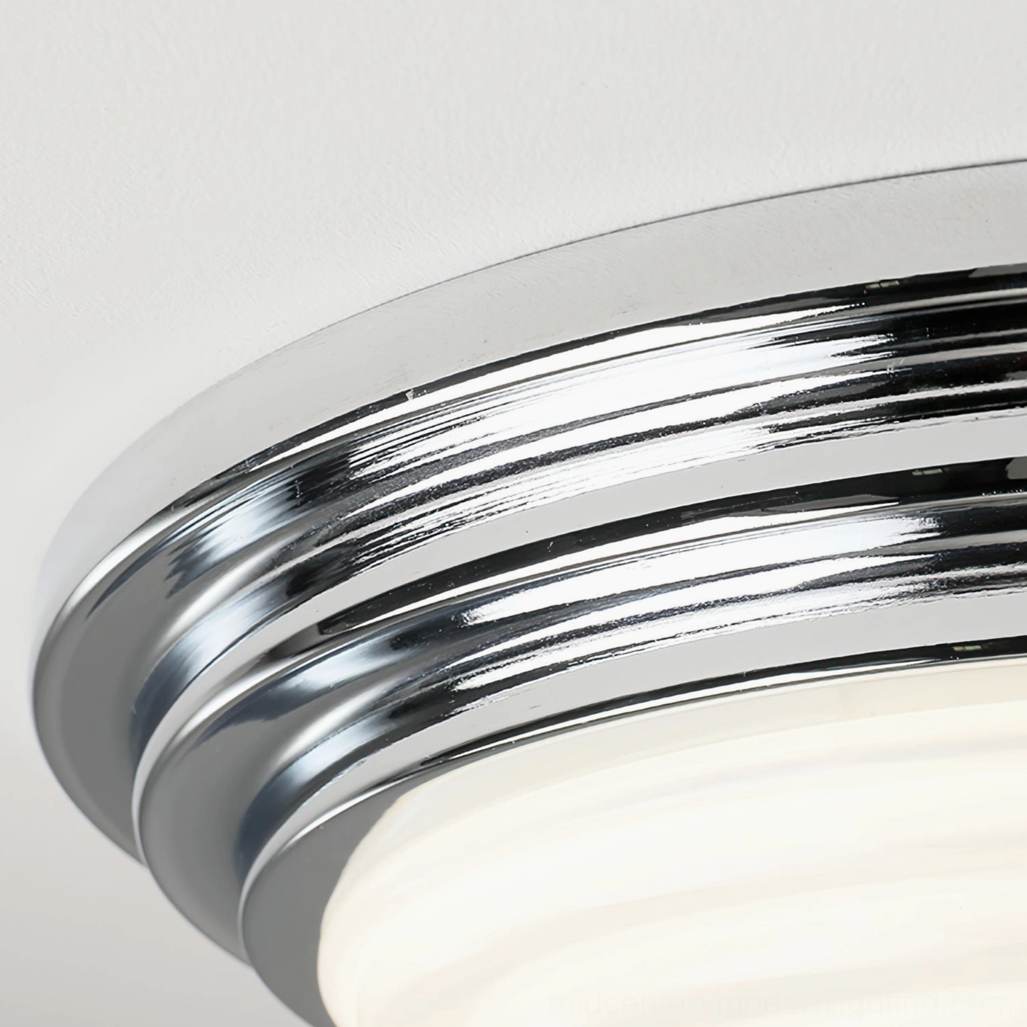 Contemporary chrome ceiling lamp mounted in modern living space, even light diffusion through frosted shade