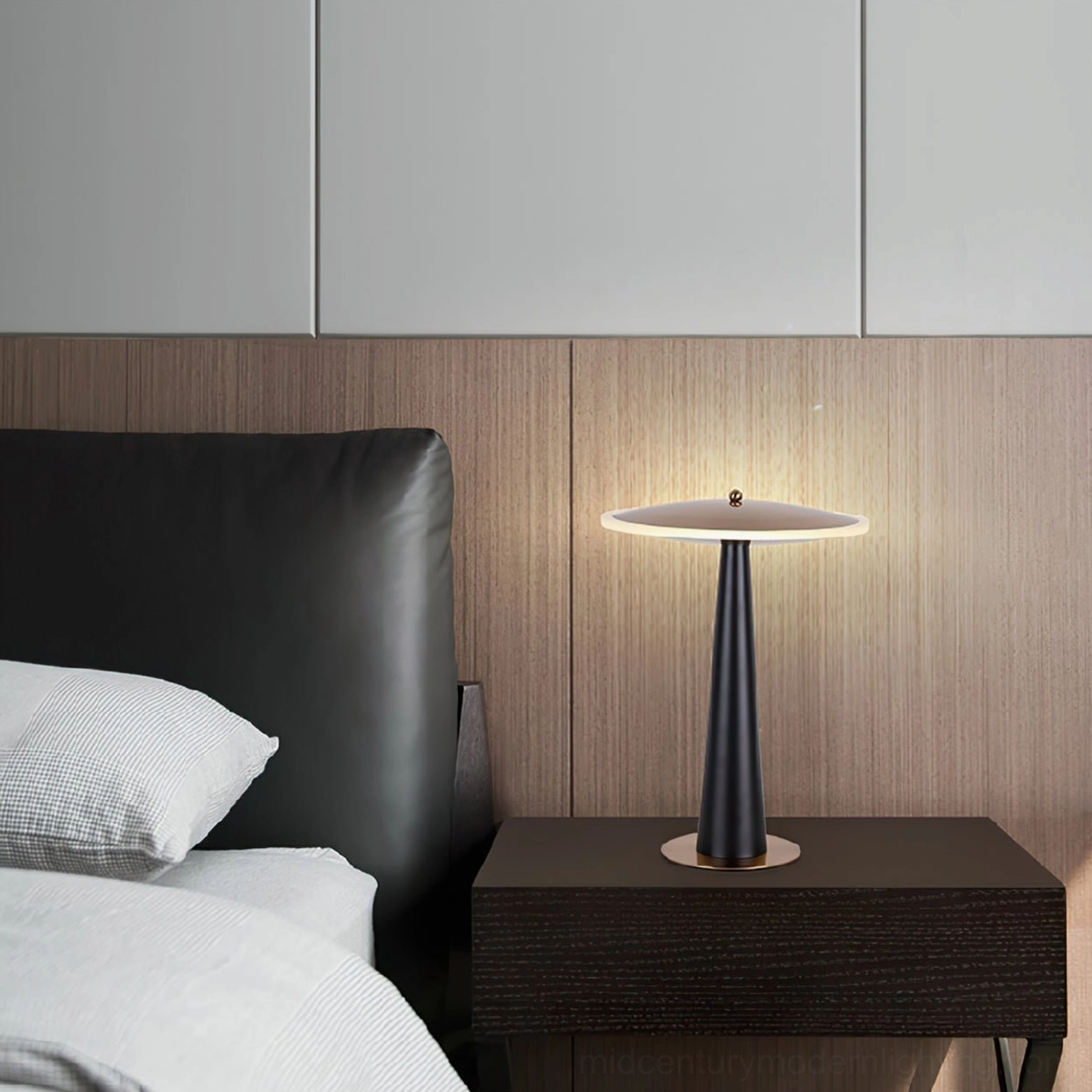 Minimalist drum lamp on dark wood bedside table in modern bedroom with leather headboard
