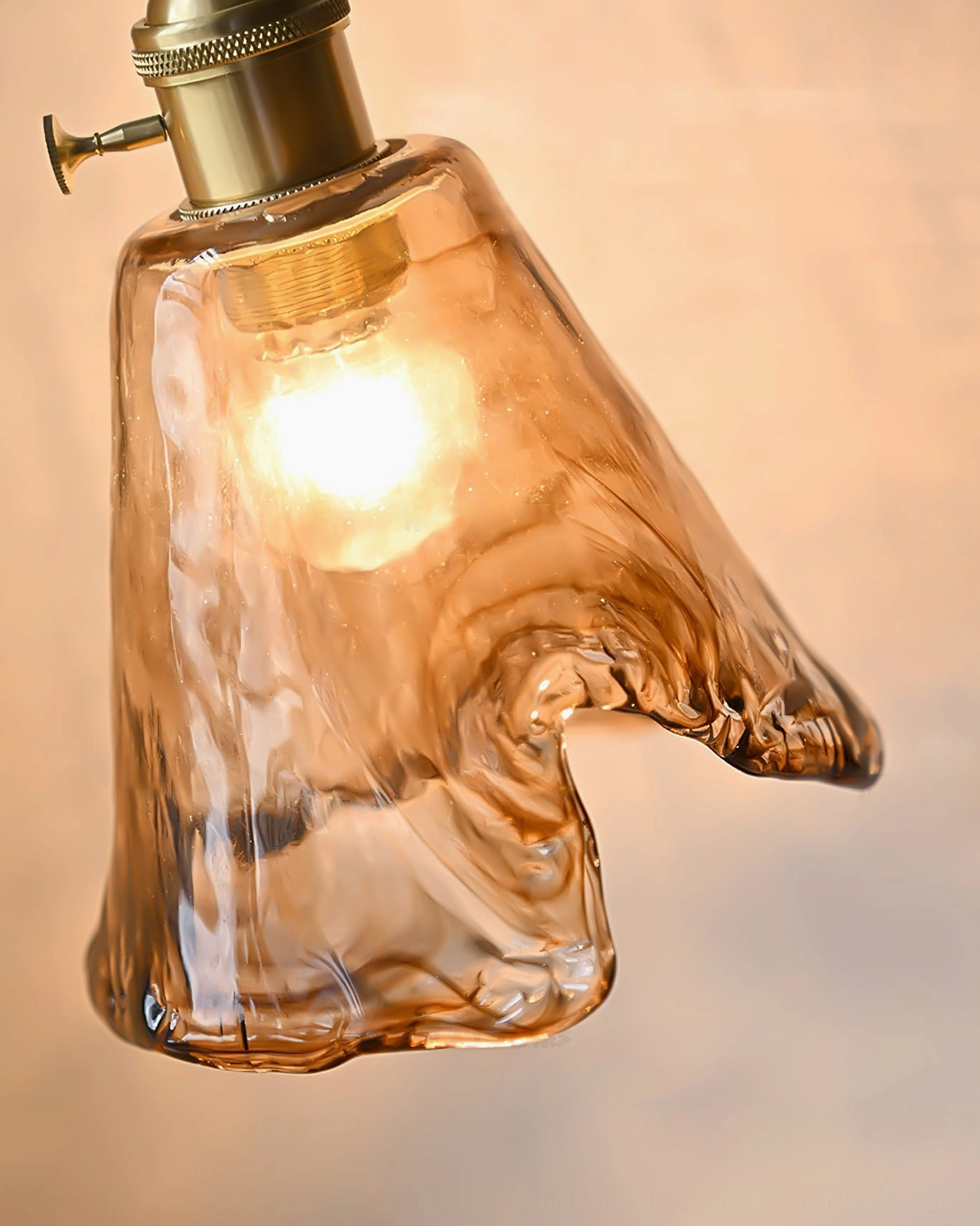 Contemporary pendant lamp with organic amber glass form mounted in modern interior space, artistic lighting