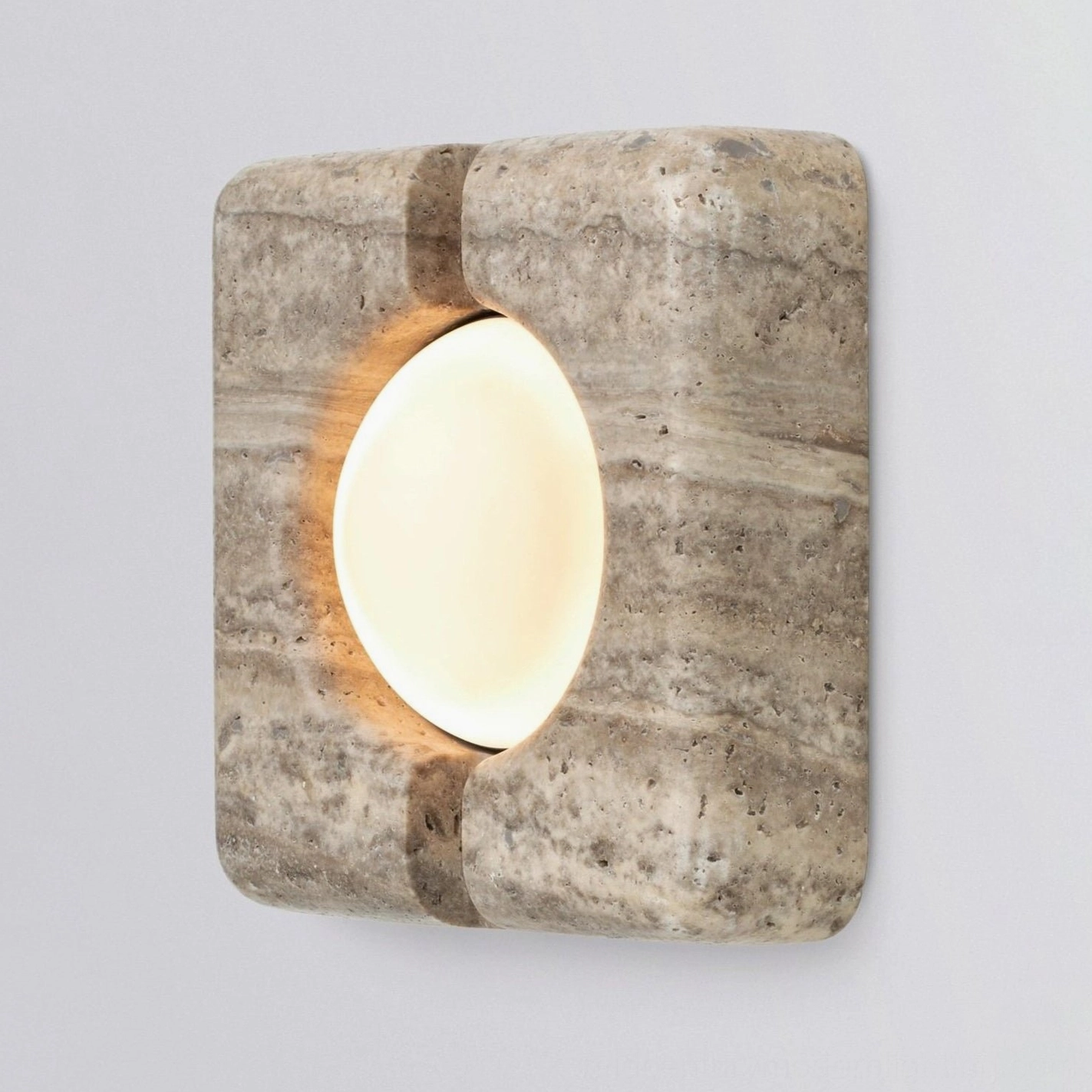 Contemporary stone wall lamp featuring natural veining and precision-cut glass element