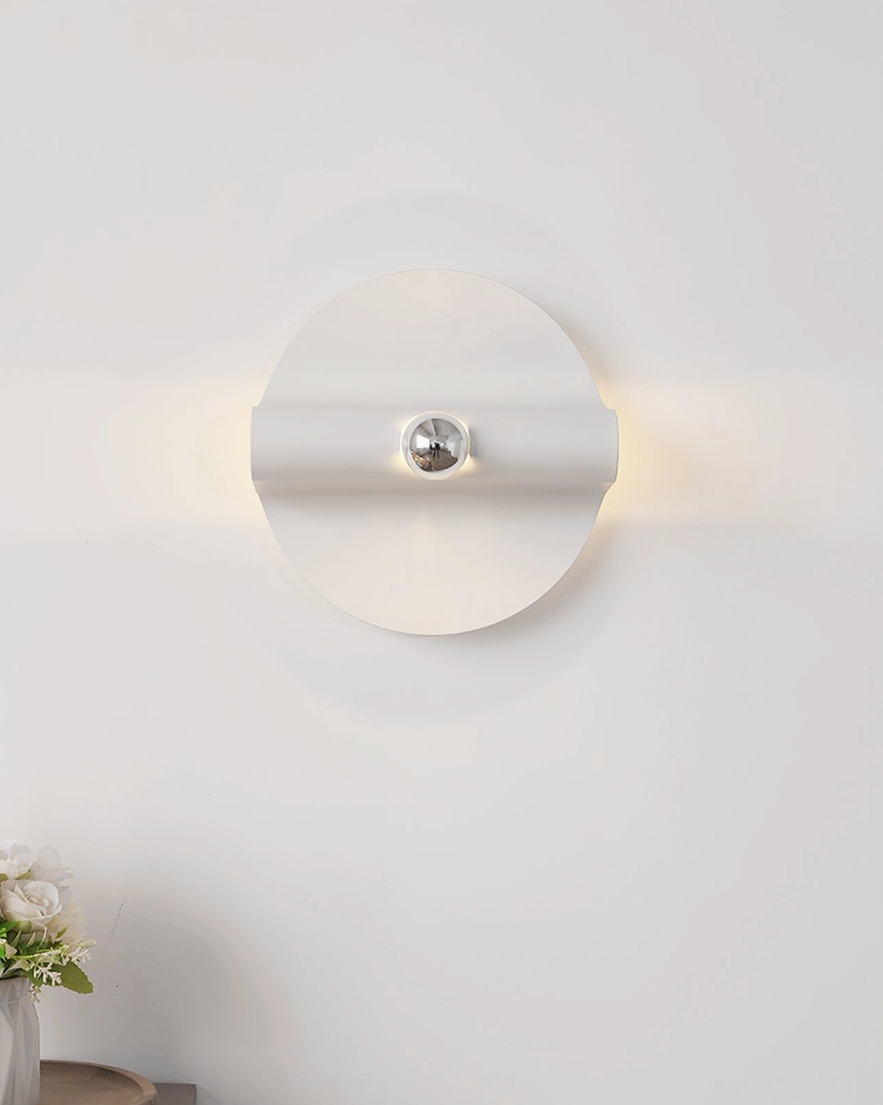 Single modern wall sconce with warm backlighting and streamlined matte white design
