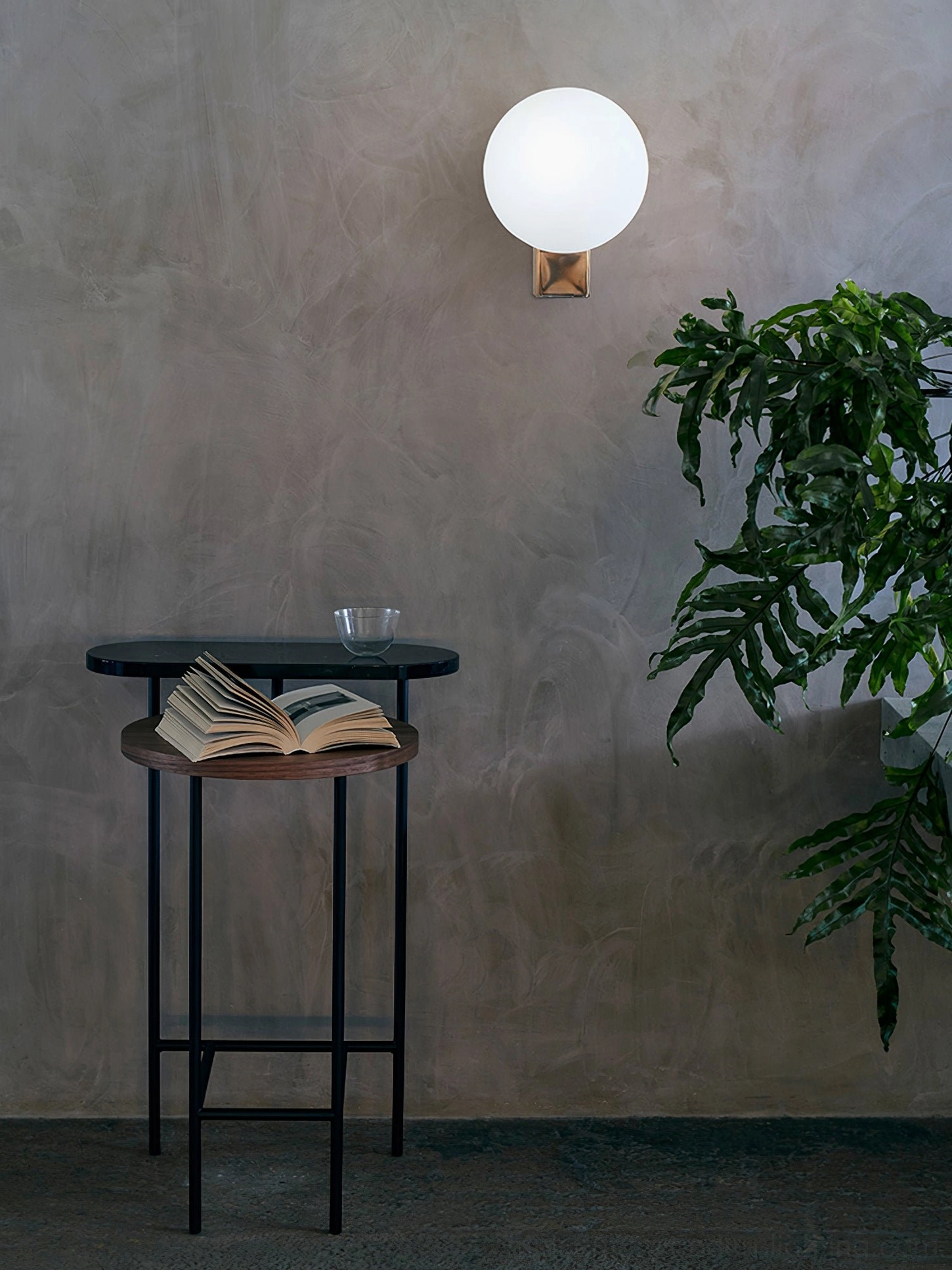 Contemporary wall-mounted geometric globe sconce with copper-toned base and frosted white glass in minimalist lounge area