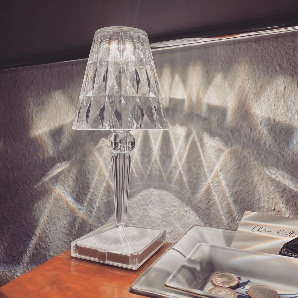 Close-up of crystal table lamp creating diamond light patterns on bedroom nightstand