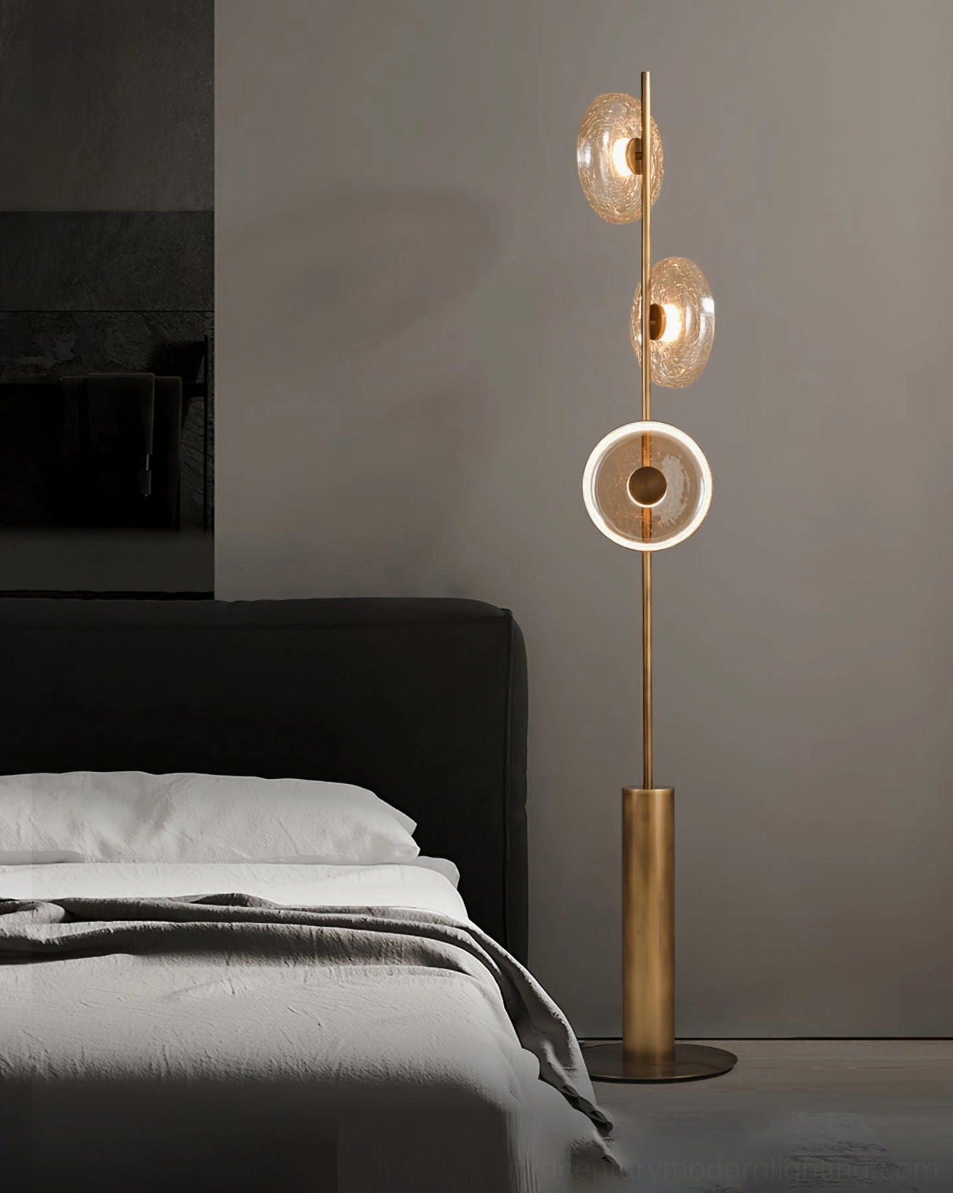 Sculptural crackle glass floor lamp positioned in contemporary bedroom corner beside upholstered linen bed