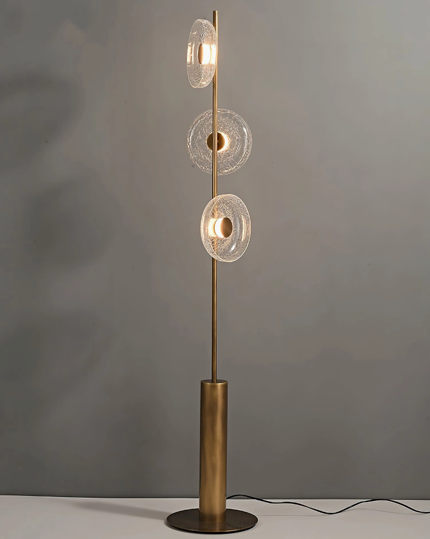 Full front view of illuminated crackle glass floor lamp with visible power cord and warm LED glow in studio