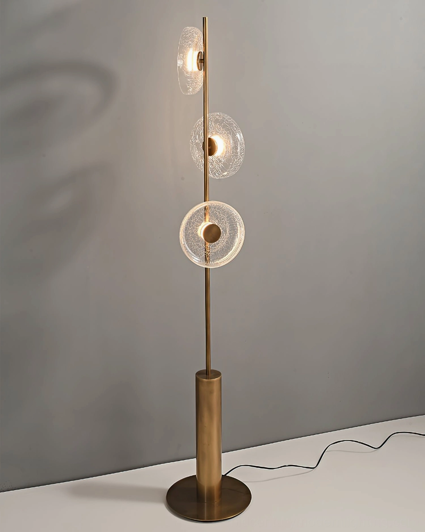 Side profile view of modern crackle glass floor lamp showing warm LED light emission and geometric design