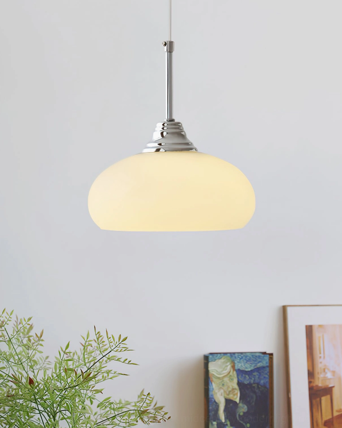 Lit Cream Bell Pendant Light casting warm glow in cozy minimalist living space with green foliage