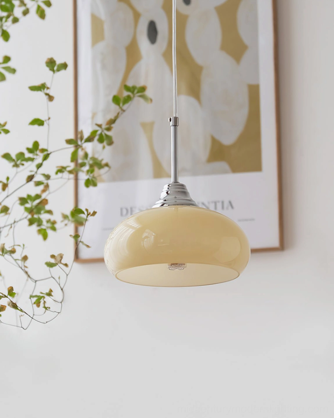 Cream Bell Pendant Light with chrome hardware beside botanical wall print and green climbing vines