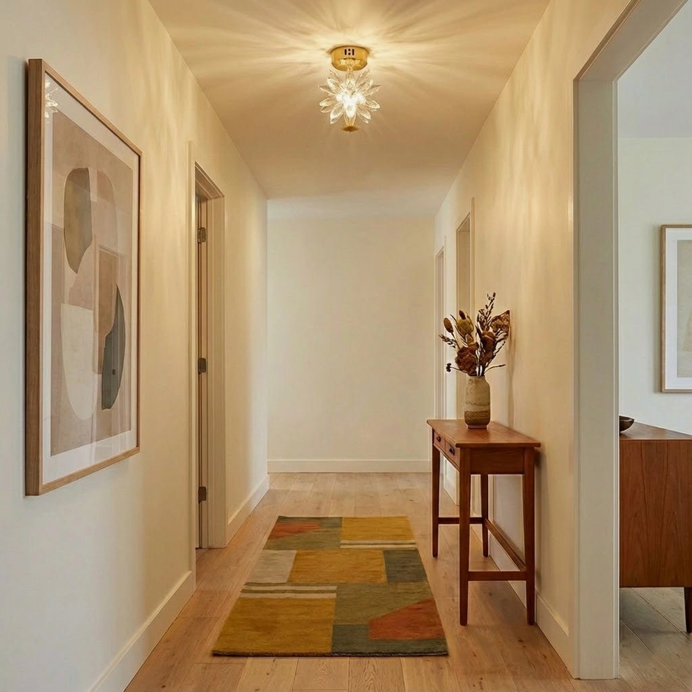 Crystal ceiling light in minimalist warm-tone corridor hallway with side table and dried floral decorative accents