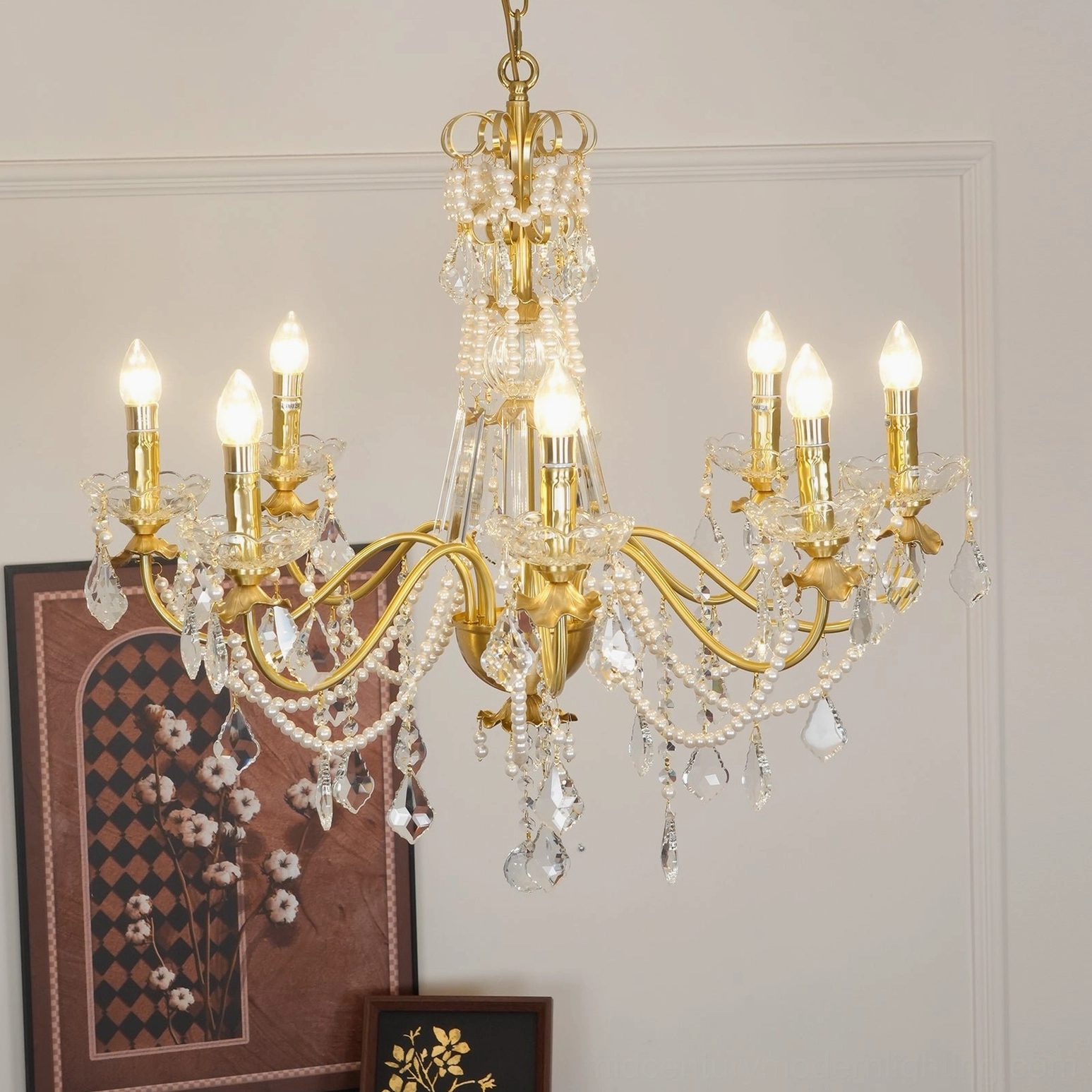 Crystal chandelier with brass candle arms and hanging crystal decorations in transitional interior