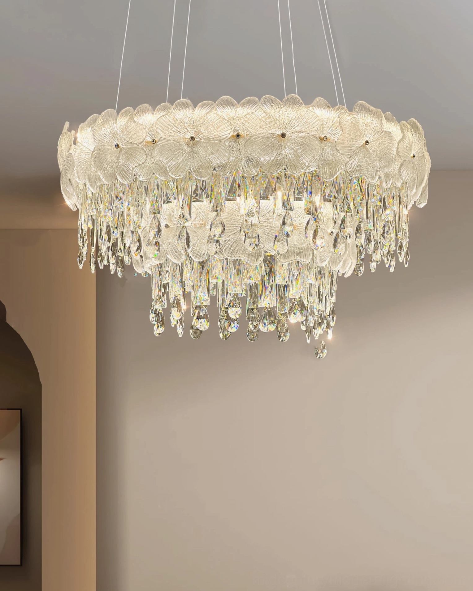 Overhead view of luxury crystal chandelier installed in warm residential interior showing light distribution and tiered crystal trim