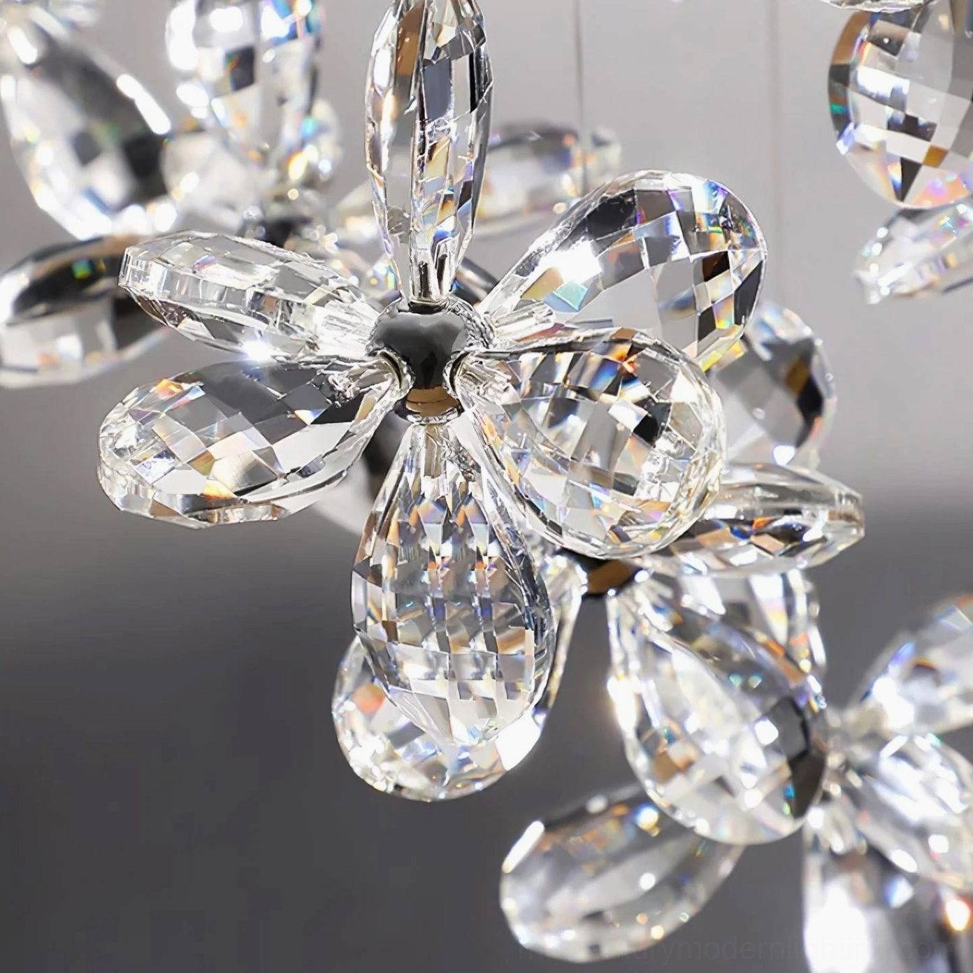 Multi-faceted crystal butterfly flower pendant with transparent clear petals, glossy metal flower center, detailed view of light refracting crystal design