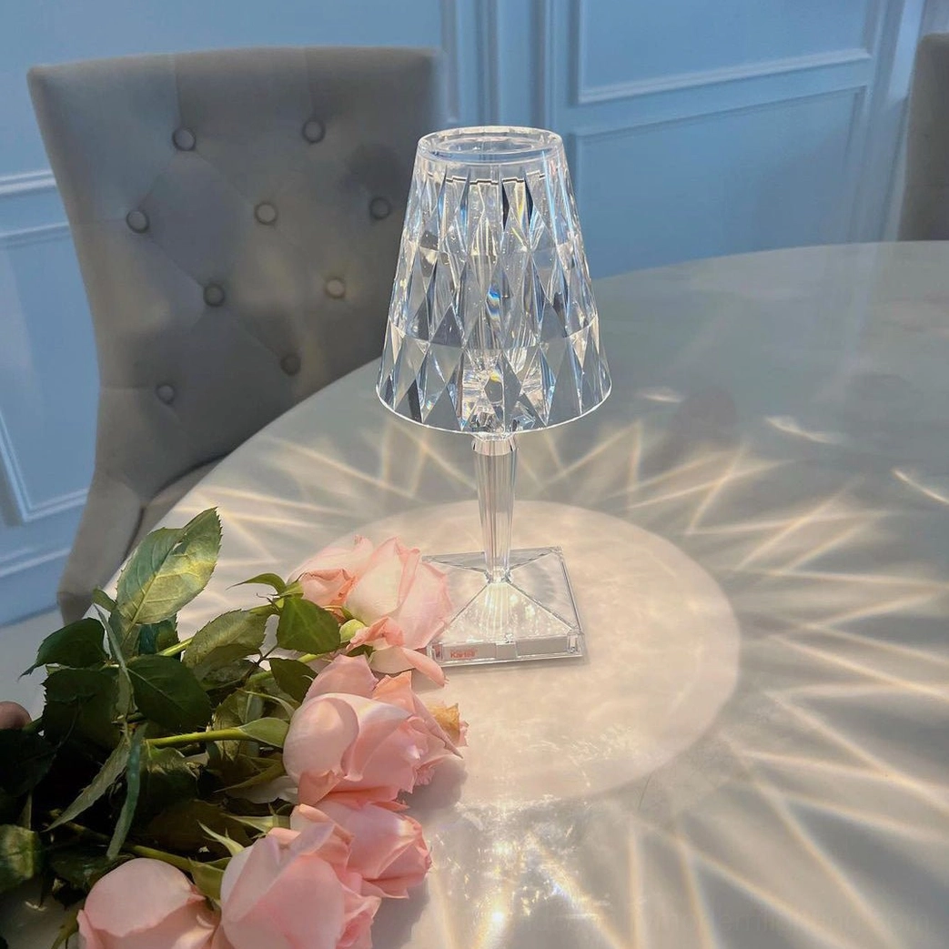Cordless crystal lamp creating dramatic atmospheric light beams in dark interior space