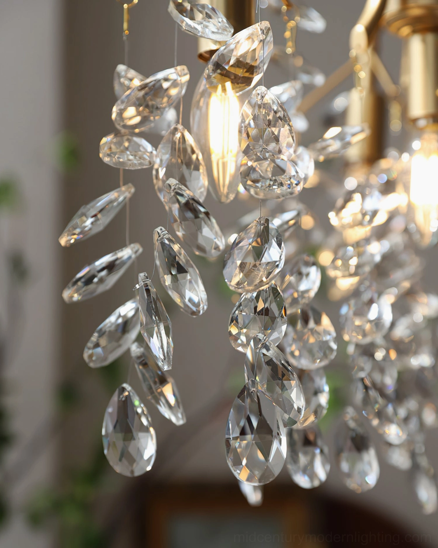 Macro close-up of faceted clear glass crystal pendants with exposed glowing warm bulb, showing light refraction through crystals