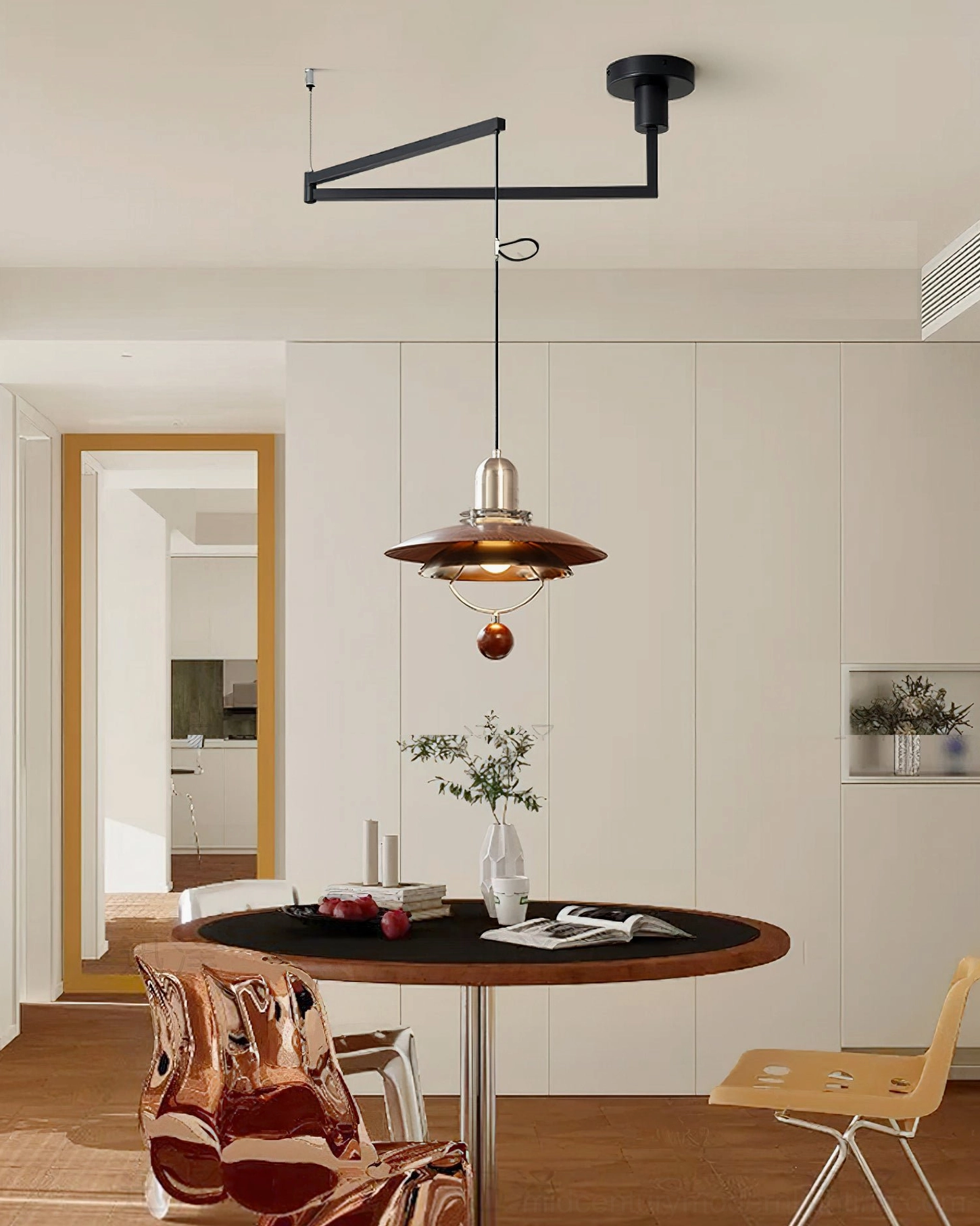 Close-up detail of swing arm pendant fixture showing brushed nickel metal base and wood grain texture of walnut shade