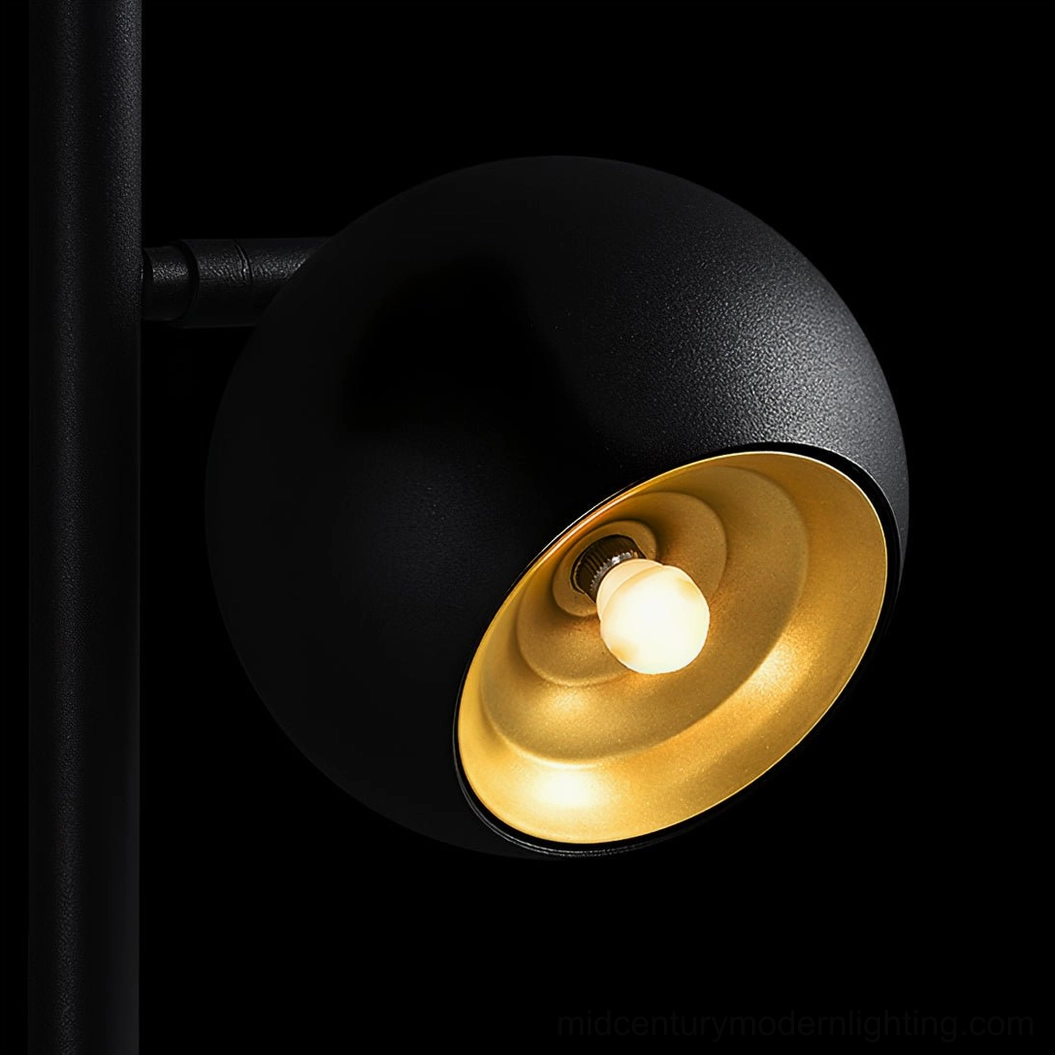 Close-up detail of Dakota floor lamp spherical shade showing matte black exterior and gold interior reflector
