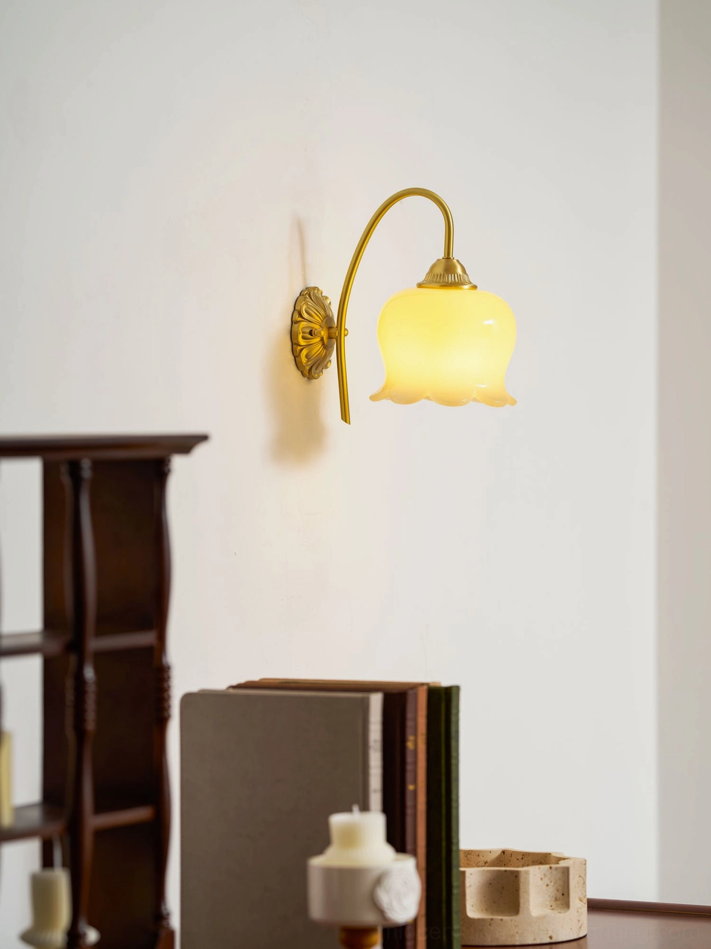 Decorative lily of the valley wall sconce with ornate brass base and floral inspired design