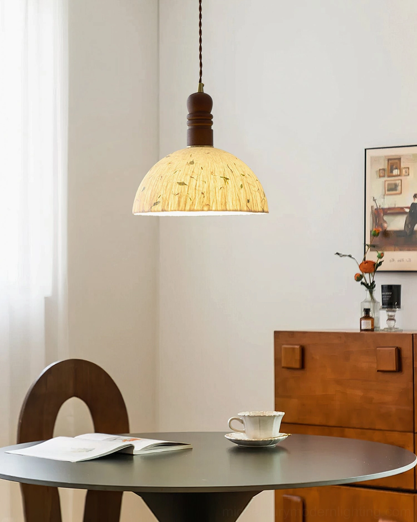 Diana pendant light hanging in residential dining area with round table, creating warm ambient lighting