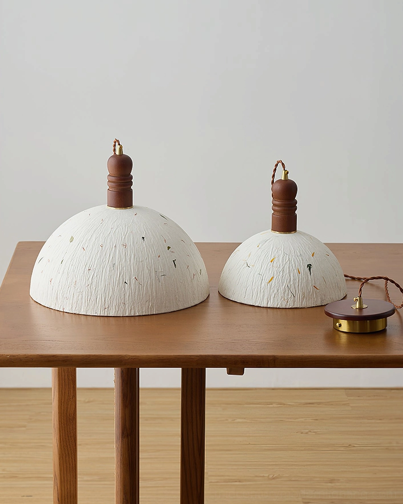 Unassembled Diana pendant lamp components including white leaf-flecked paper shades and brass mounting hardware