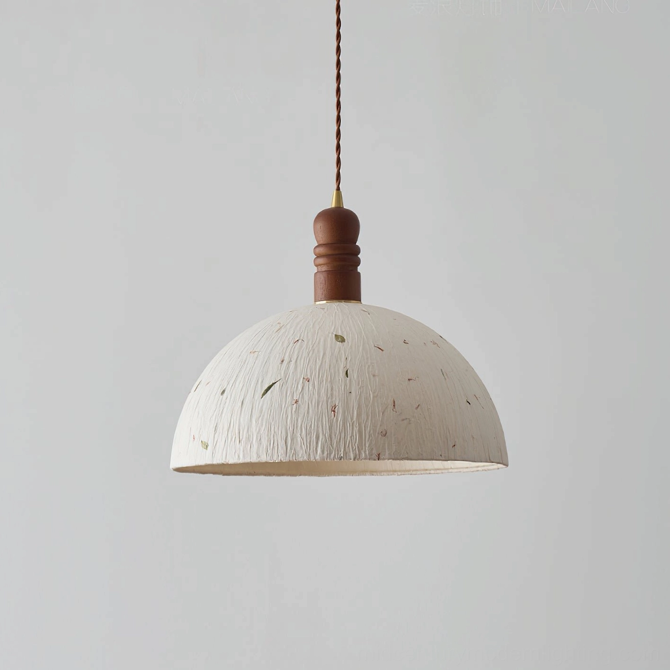 Diana pendant light with off-white textured paper dome shade and solid walnut wood fixture, studio front view