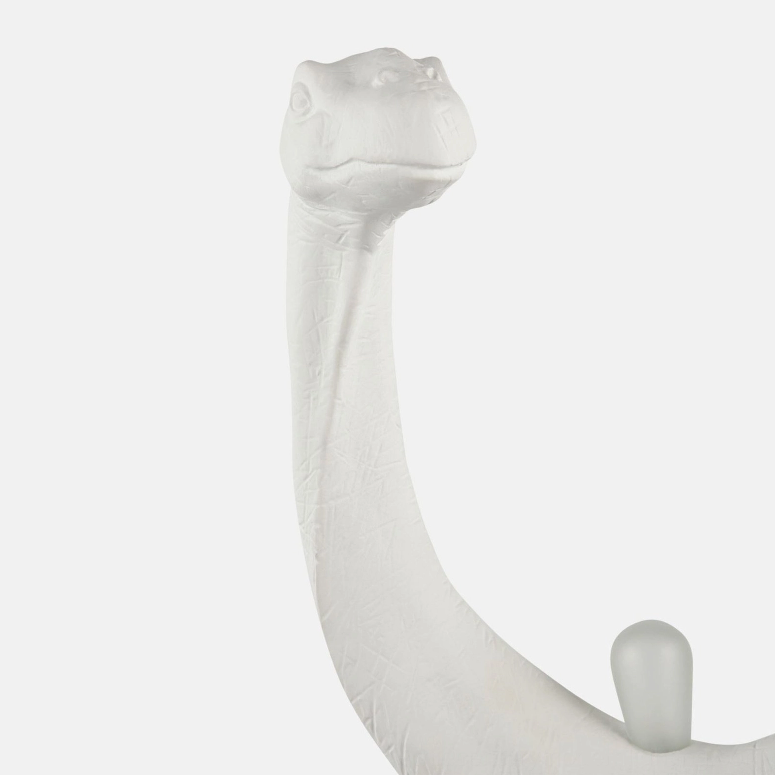 Dinosaur head table lamp with simplified sculptural design, close-up side view on white background