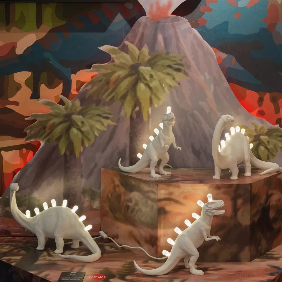 Collection of dinosaur table lamps in exhibition display, varied silhouettes with glowing LED accents