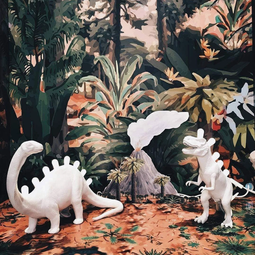 Matte white dinosaur table lamp with LED spine bulbs, front-facing product photography
