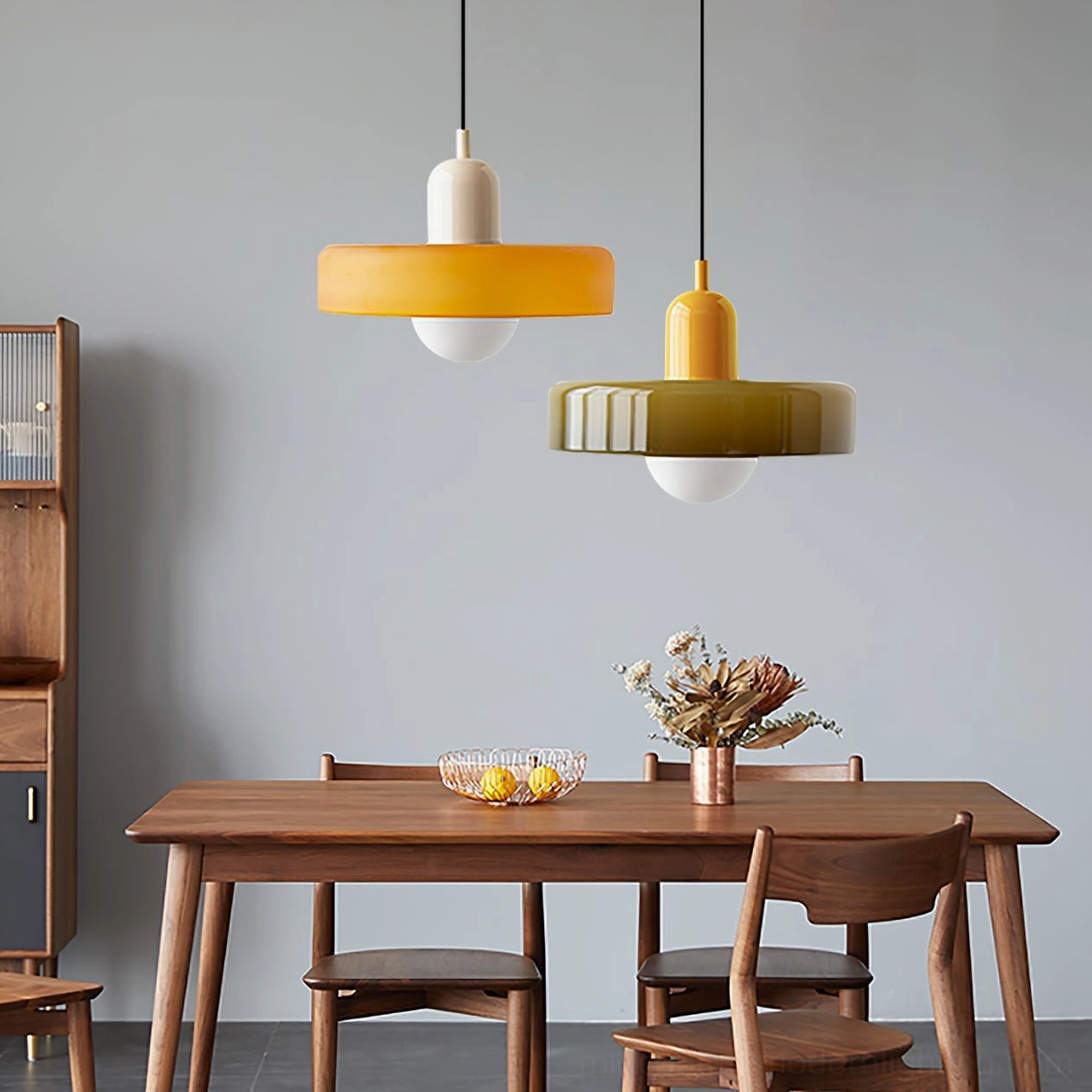Disc Orb Pendant Lights in yellow and olive green finishes above wooden dining table