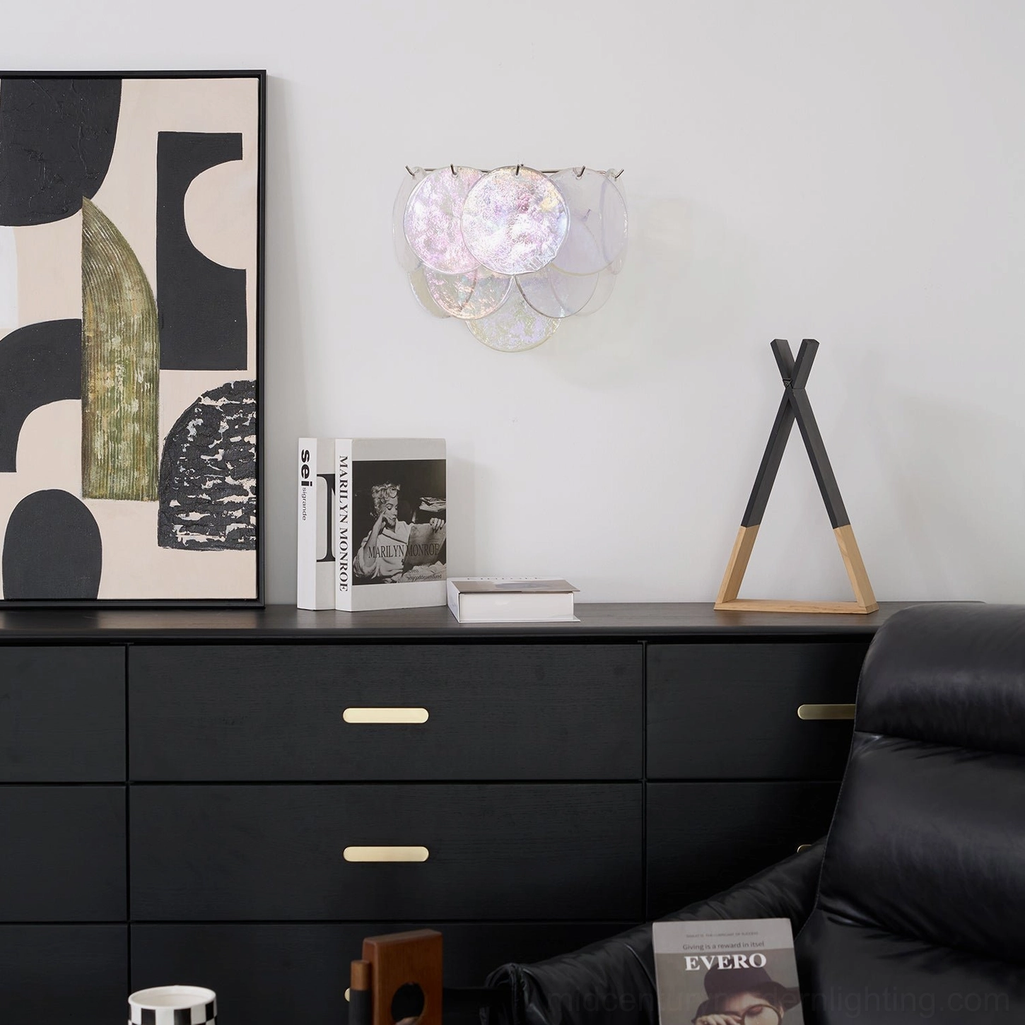 Clear glass disc wall lamp mounted in minimalist living room, showing side profile and light refraction