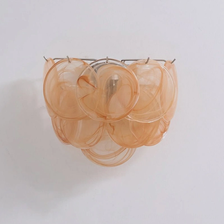 Orange gradient tinted disc wall lamp, studio front view showing artisanal glass pattern