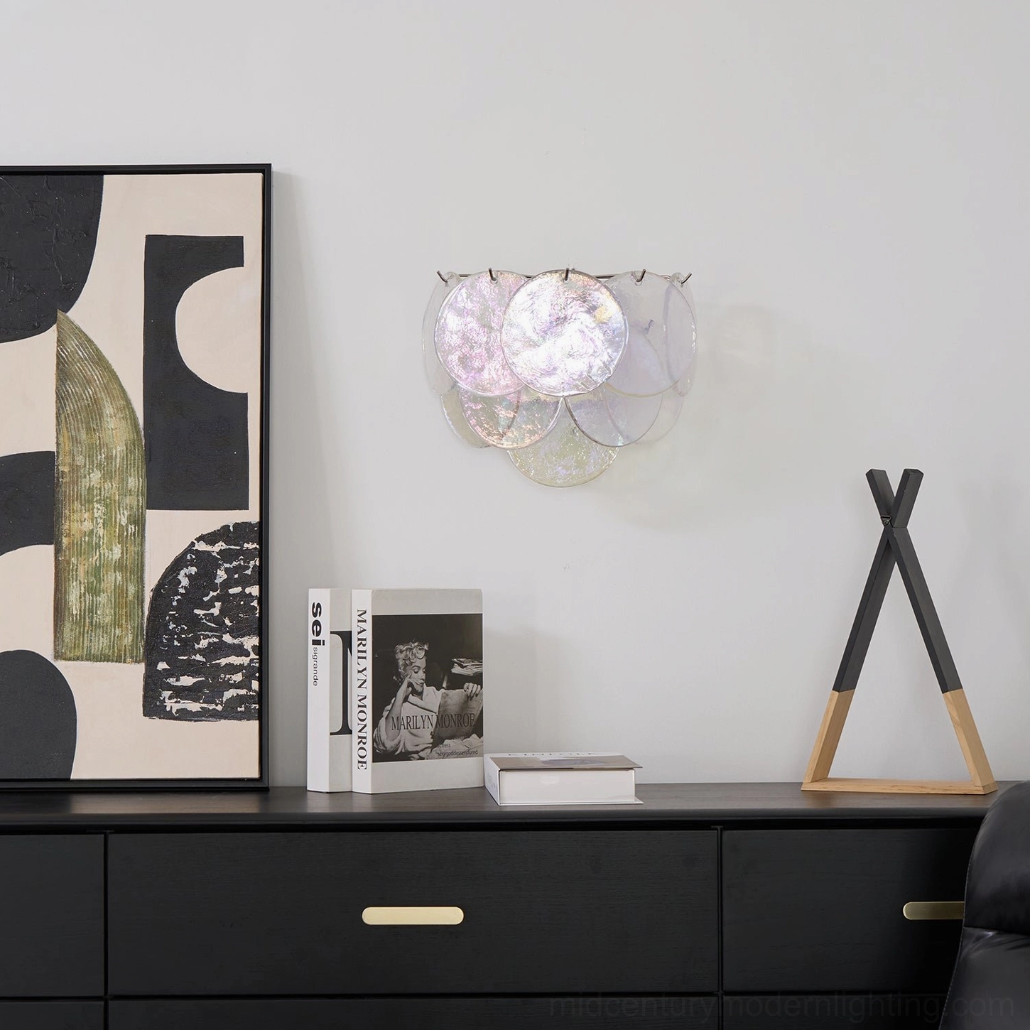 Pale pink clear glass disc wall lamp in contemporary home decor setting, front view installation