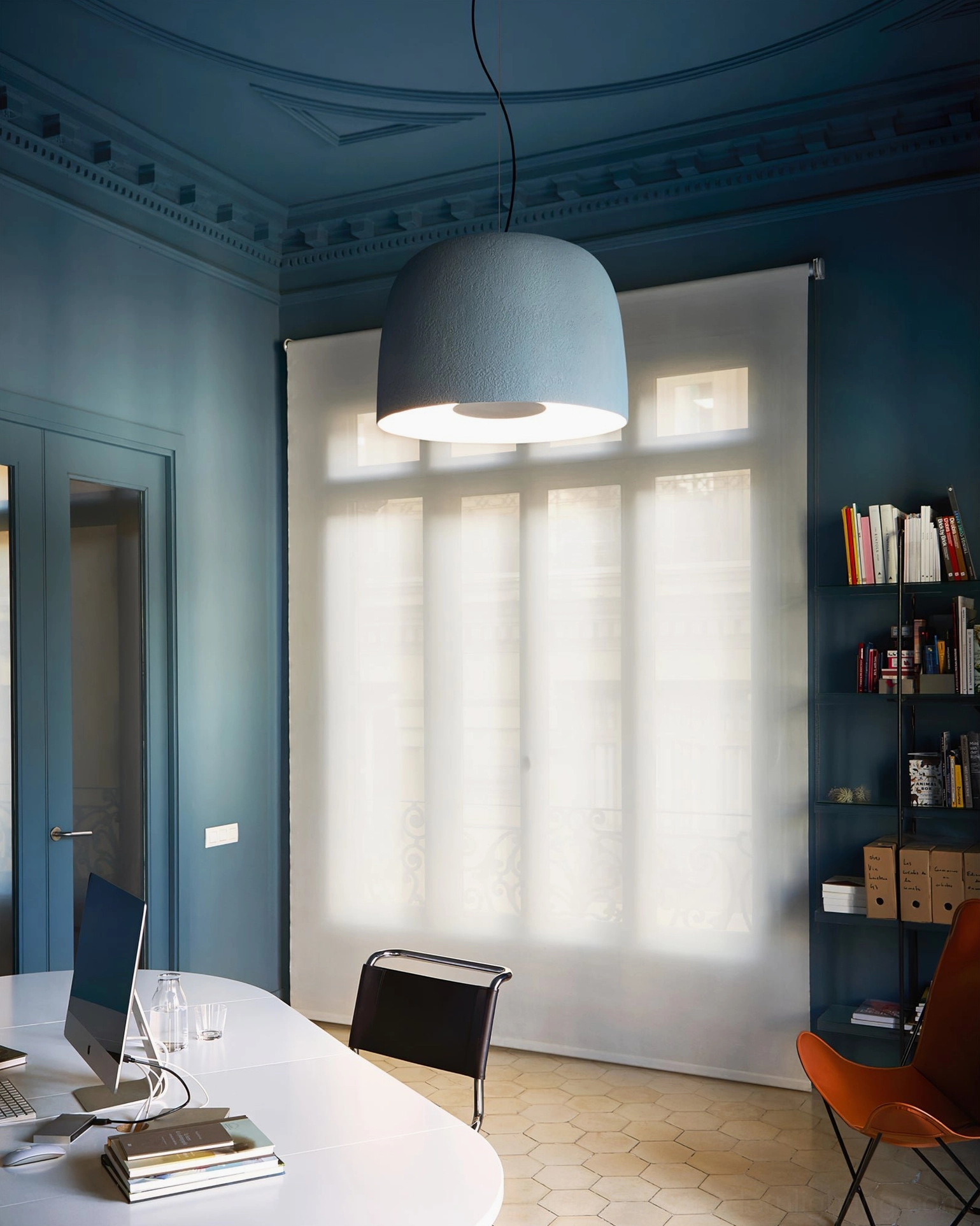 Light grey Djembe pendant lamp in home study room with blue walls and built-in bookshelf