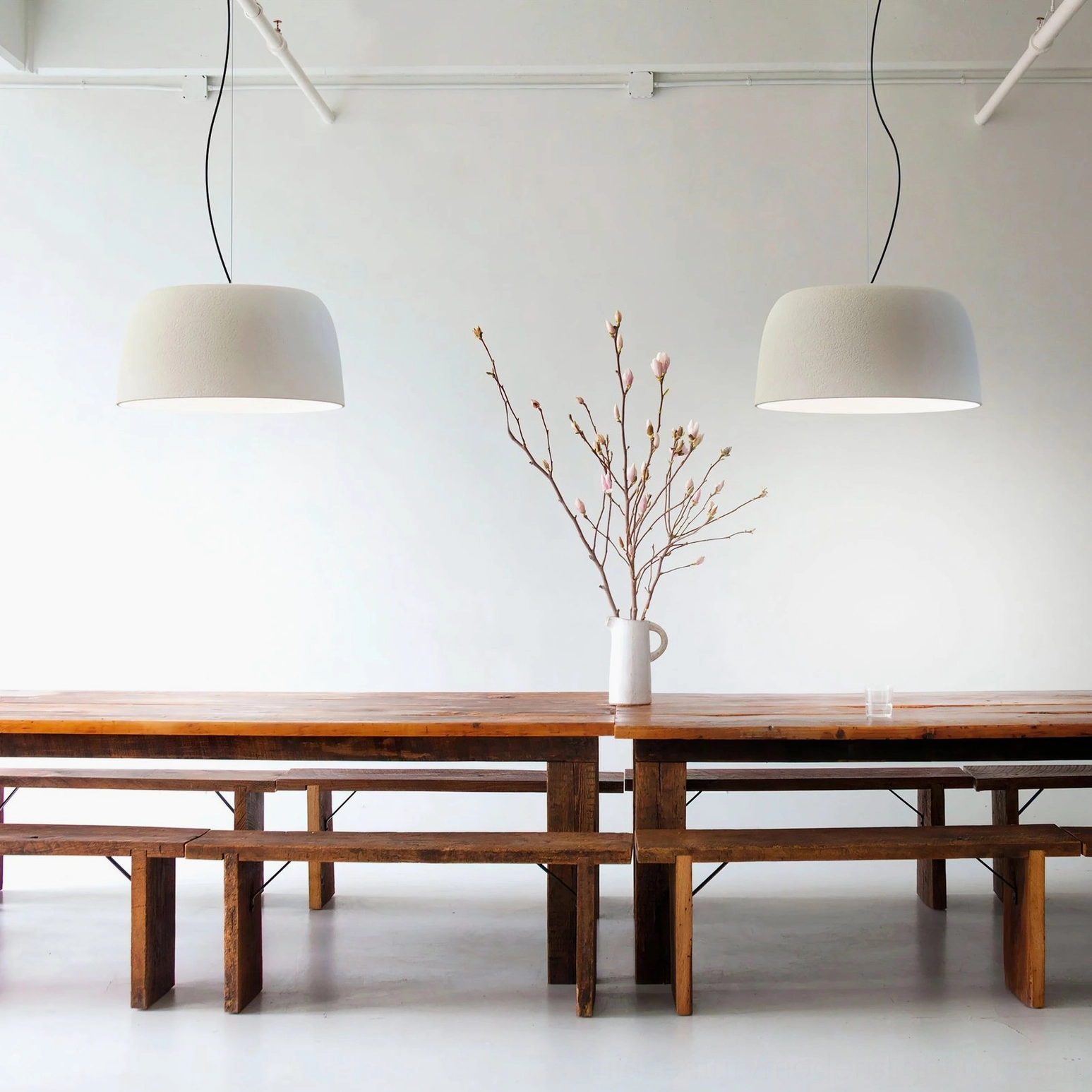 Multiple Djembe pendant lamps in different sizes creating layered lighting composition