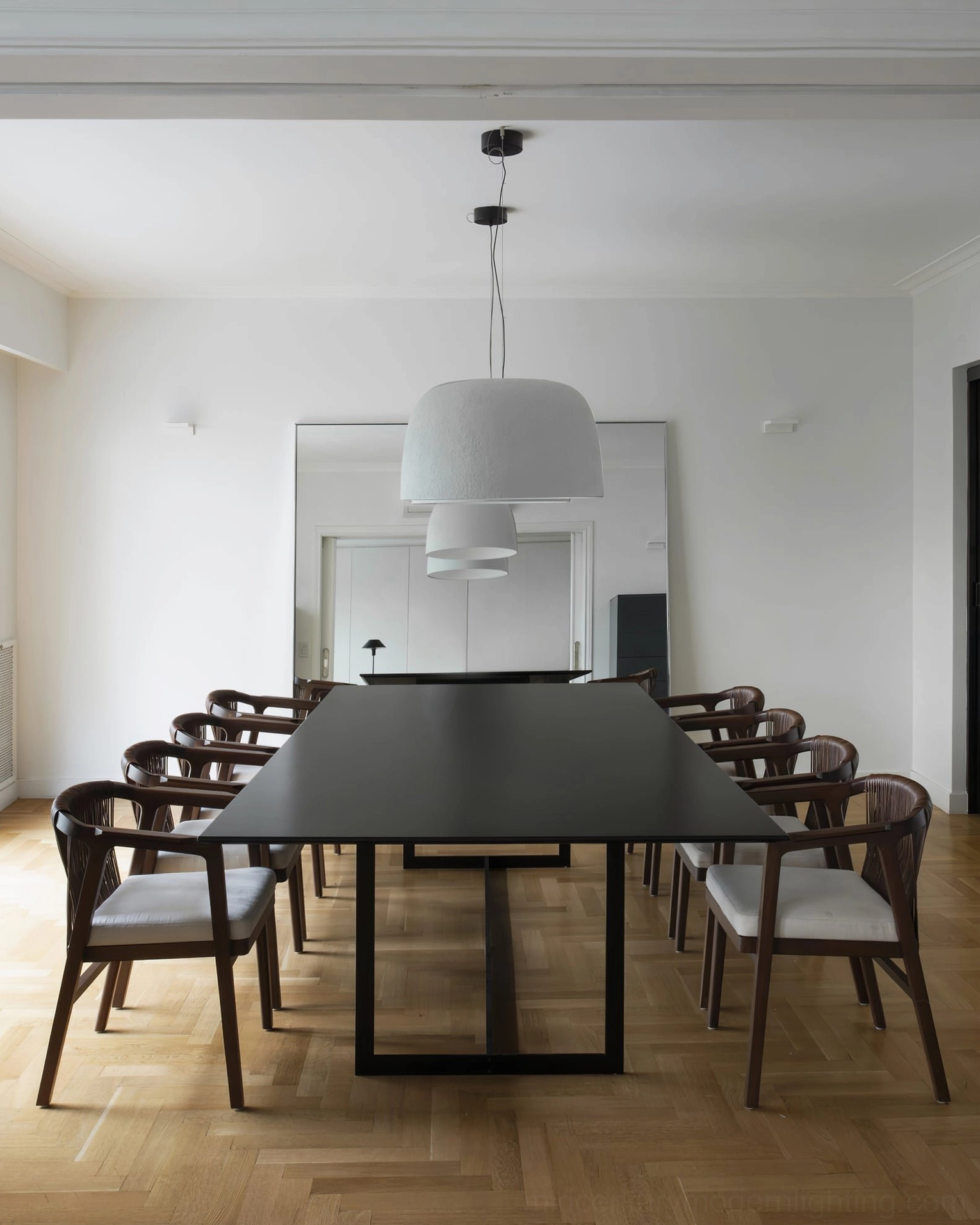 Stacked double white Djembe pendant lamps above long conference table in modern dining room