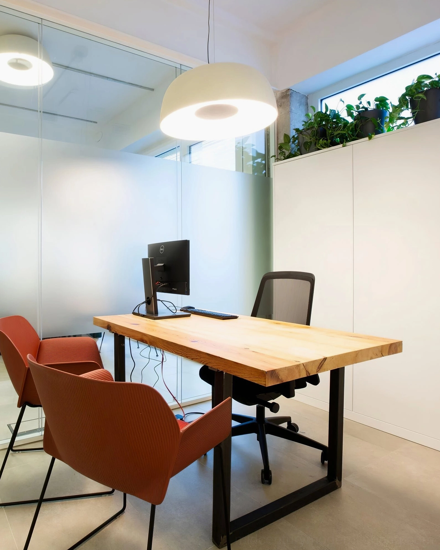 Off-white Djembe pendant lamp above home office desk with wooden furniture and green plants