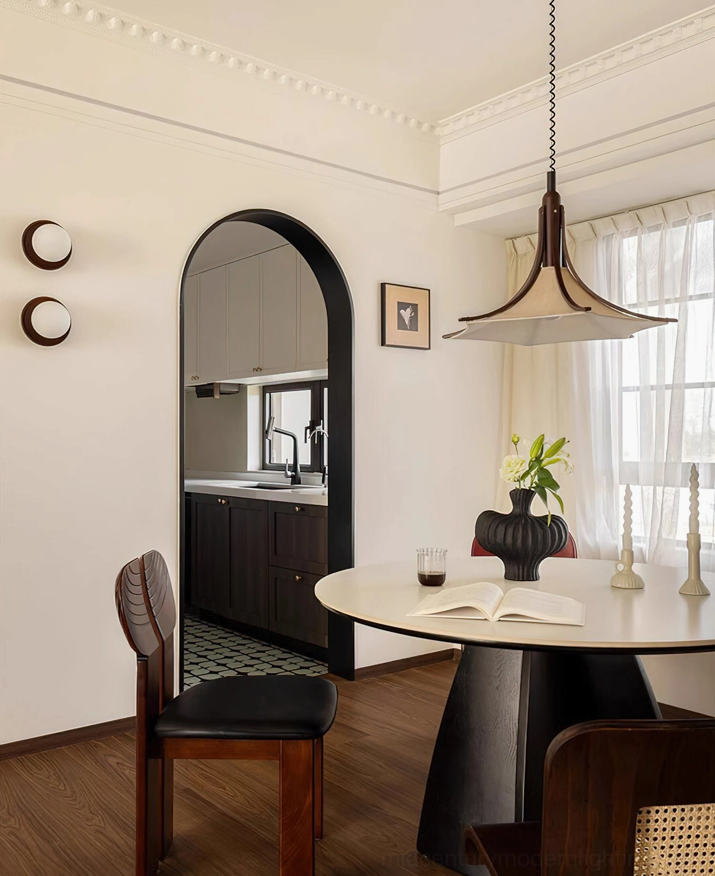 Modern vintage pendant light hanging above round dining table in cozy dining space