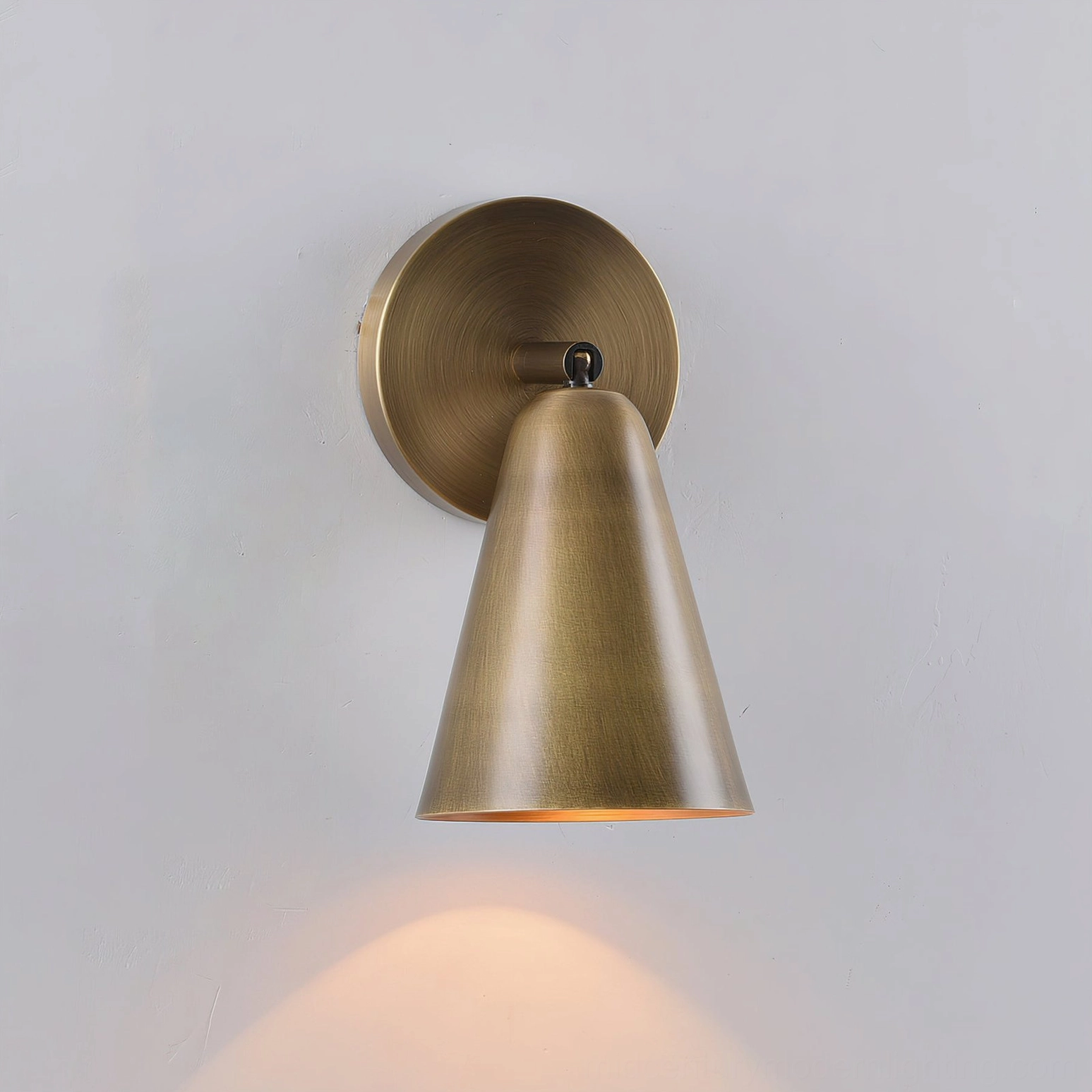 Donna wall sconce with integrated swivel mechanism and solid brass backplate