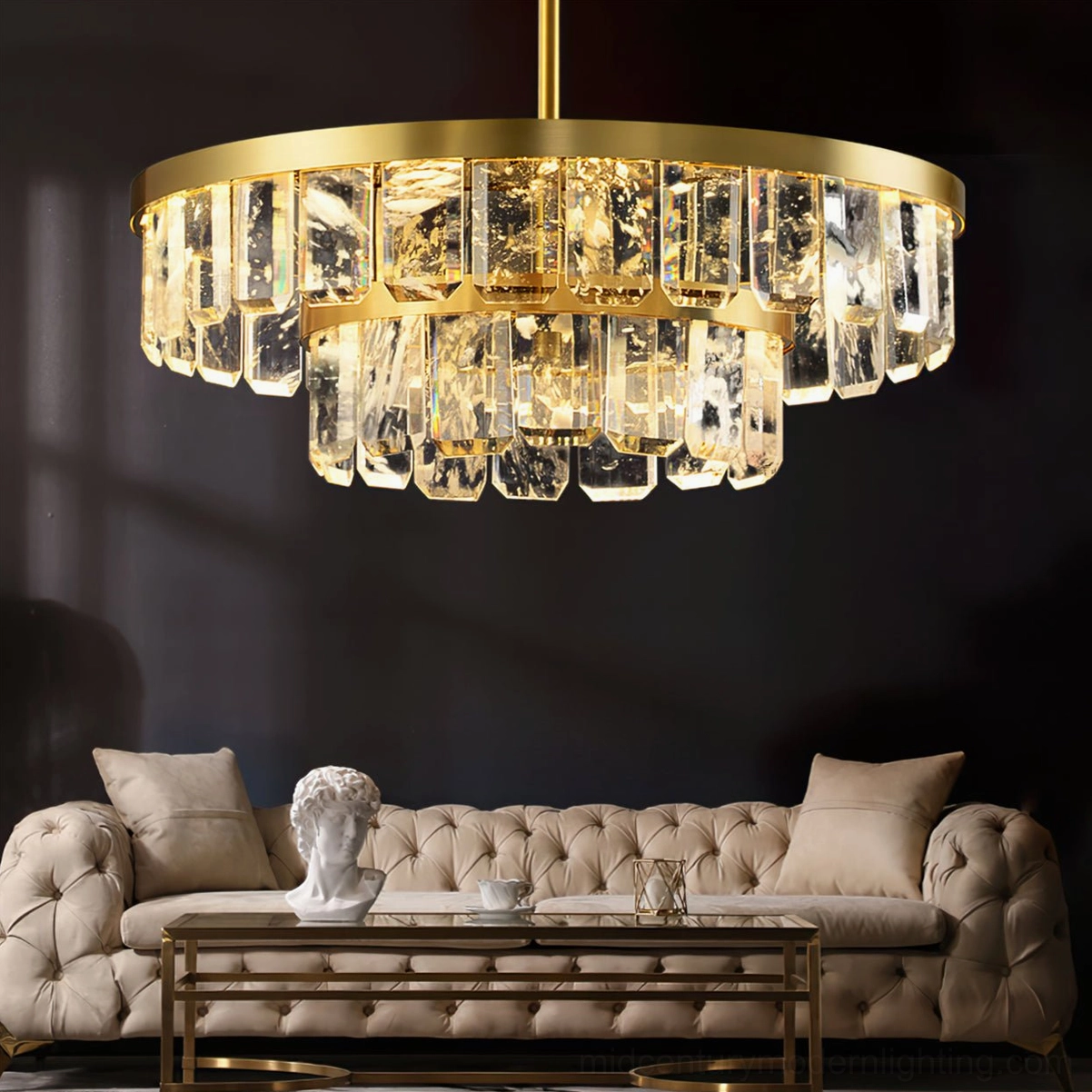 Two-tier Doria crystal chandelier in luxury modern living room with tufted sofa and brass warm lighting