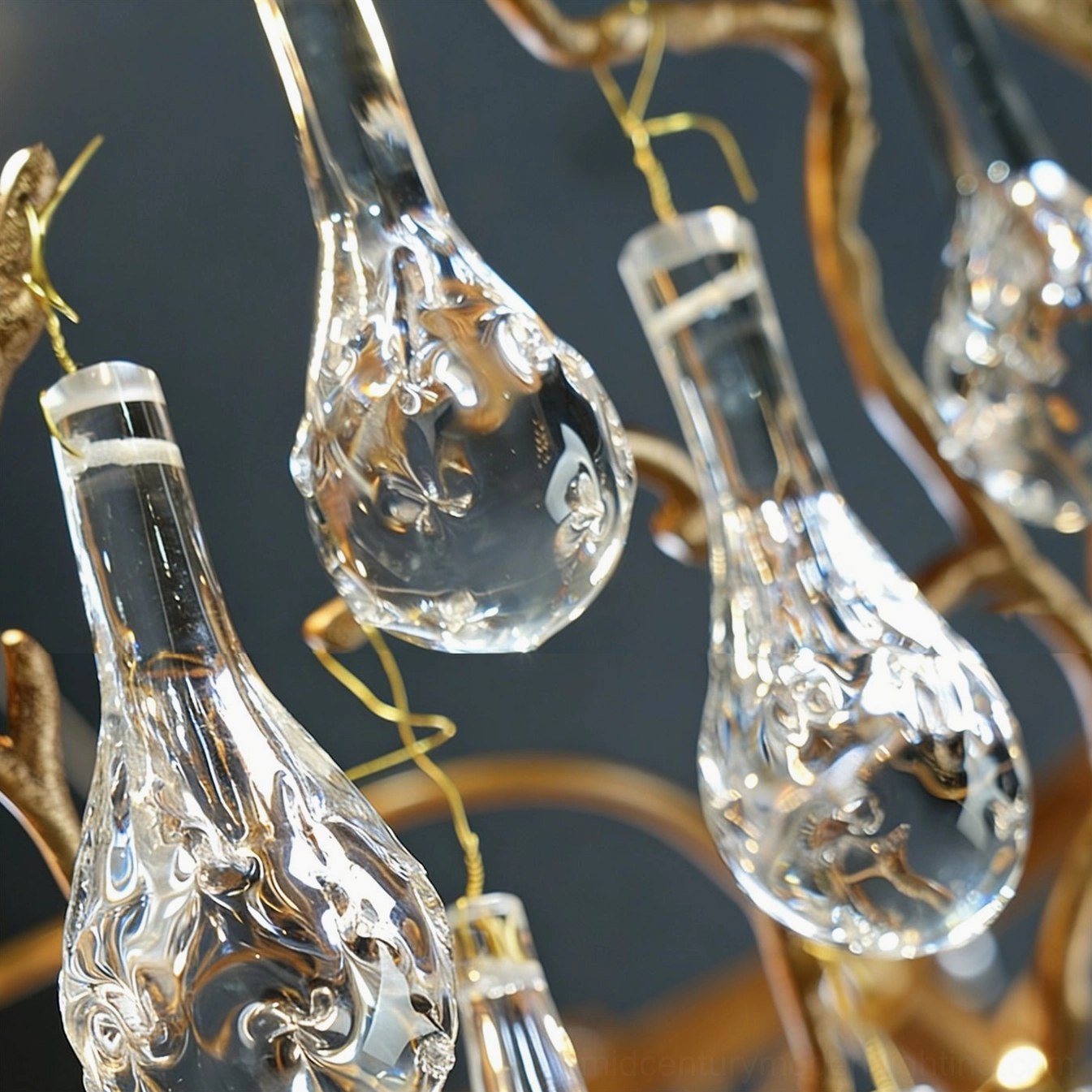 Doris mid-century chandelier low angle close-up emphasizing faceted glass pendant refraction and textured antique brass branch structure
