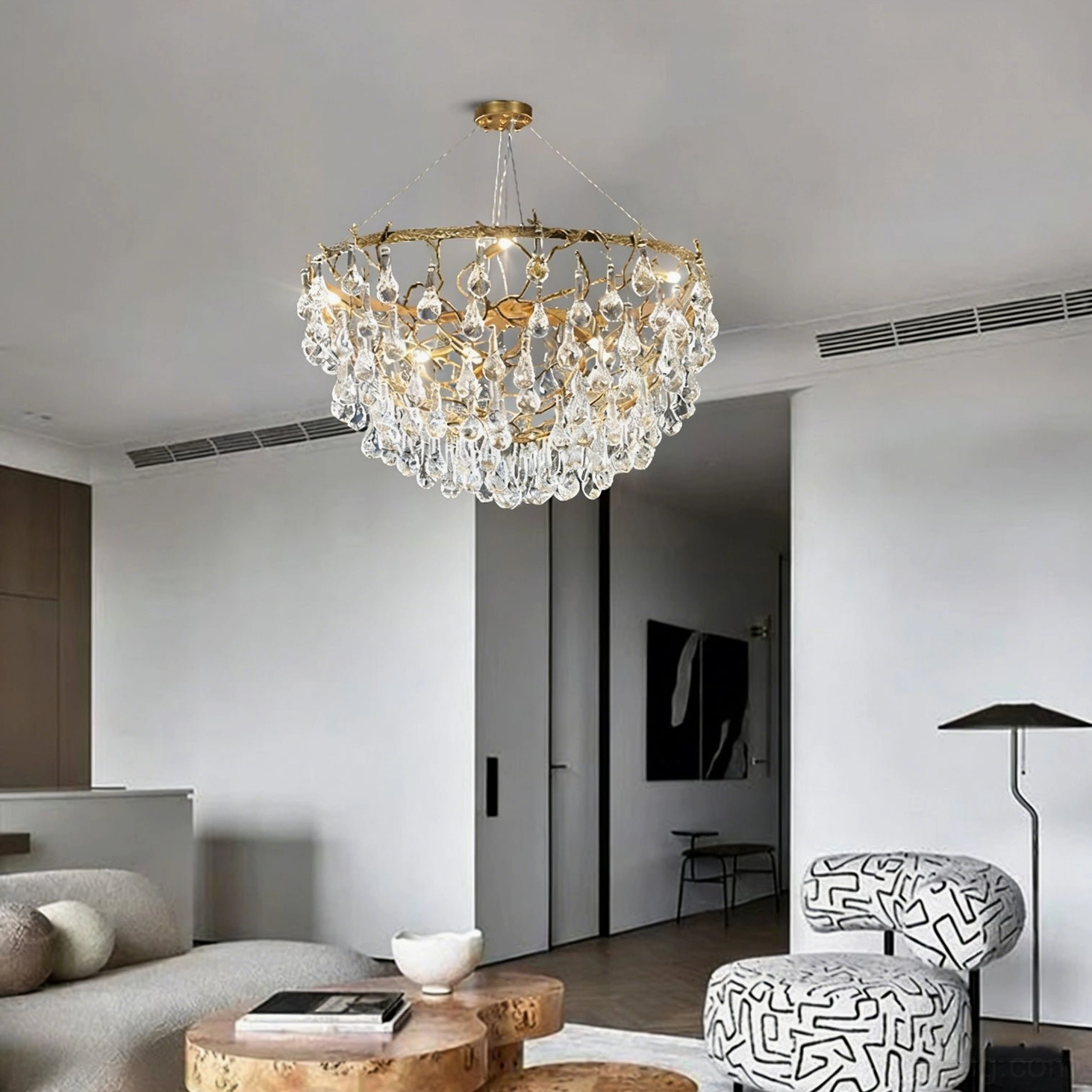Doris mid-century modern crystal chandelier mounted above dining table in minimalist living room with architectural brass framework detail