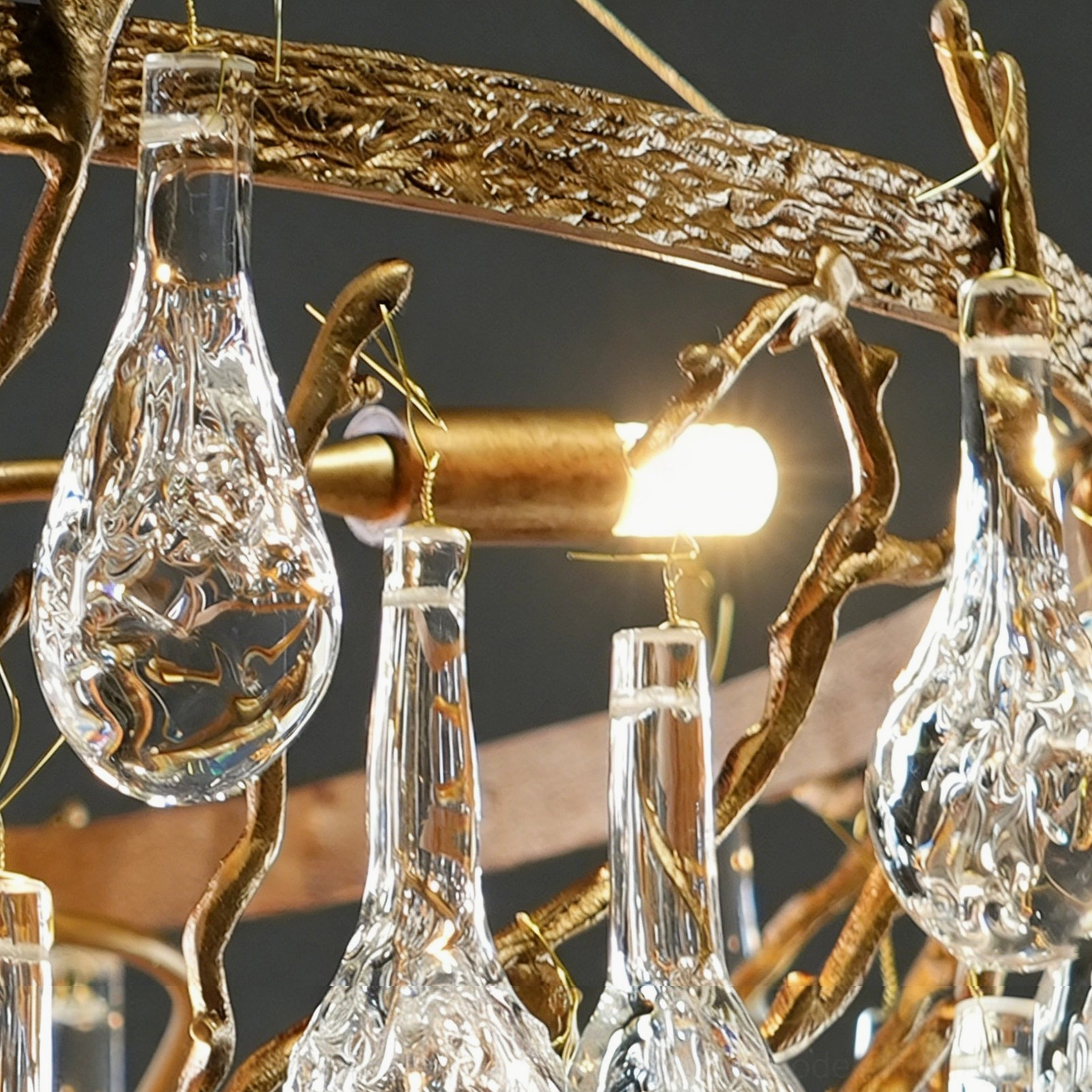 Branch-style Doris crystal chandelier side view showing individual glass teardrop suspension and antique brass organic geometry against dark background