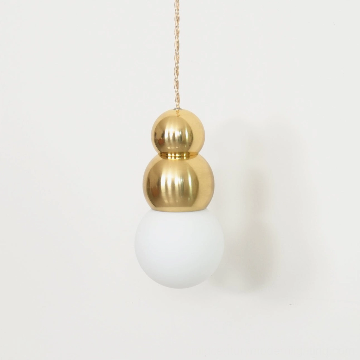 Double brass spheres frosted glass wall light, close-up detail, braided fabric cord, mid-century pendant
