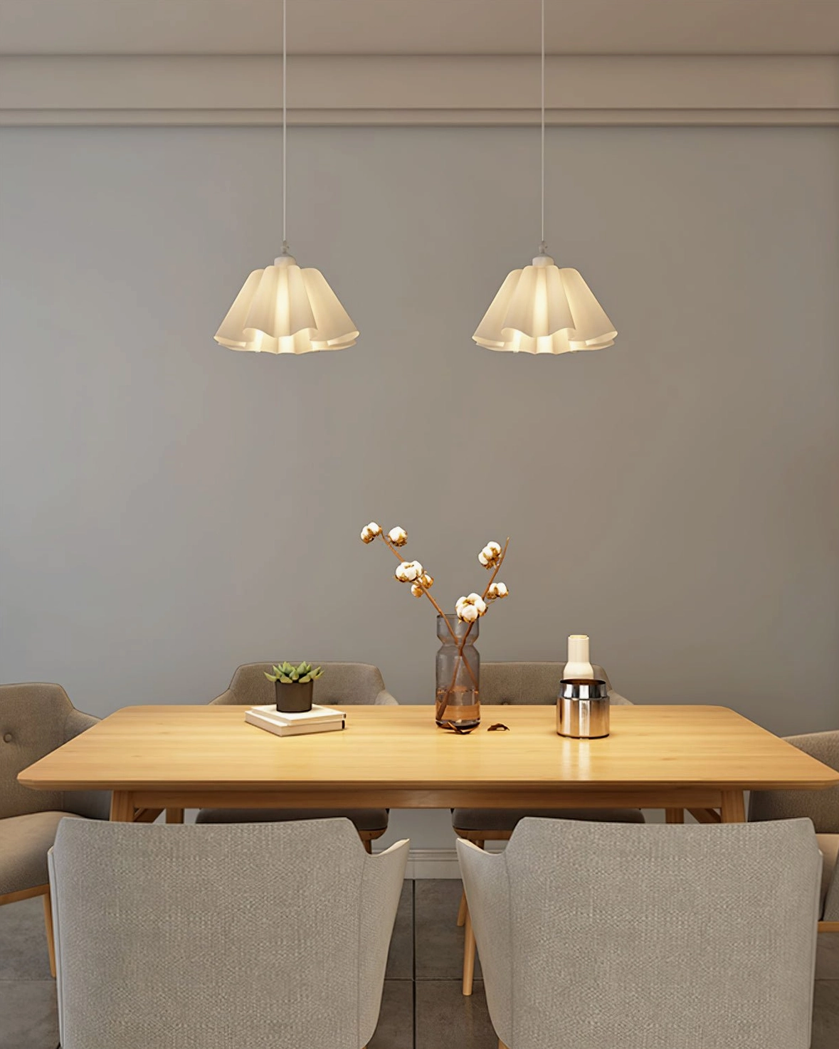 Twin pleated pendant lights hanging above wooden dining table in minimalist warm home interior
