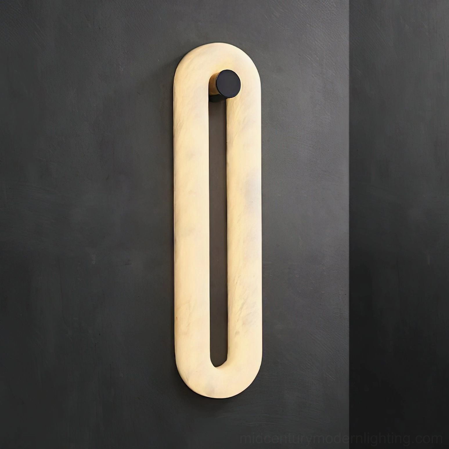 Dromo modern wall sconce glowing with warm LED light against dark gray wall, sculptural alabaster fixture