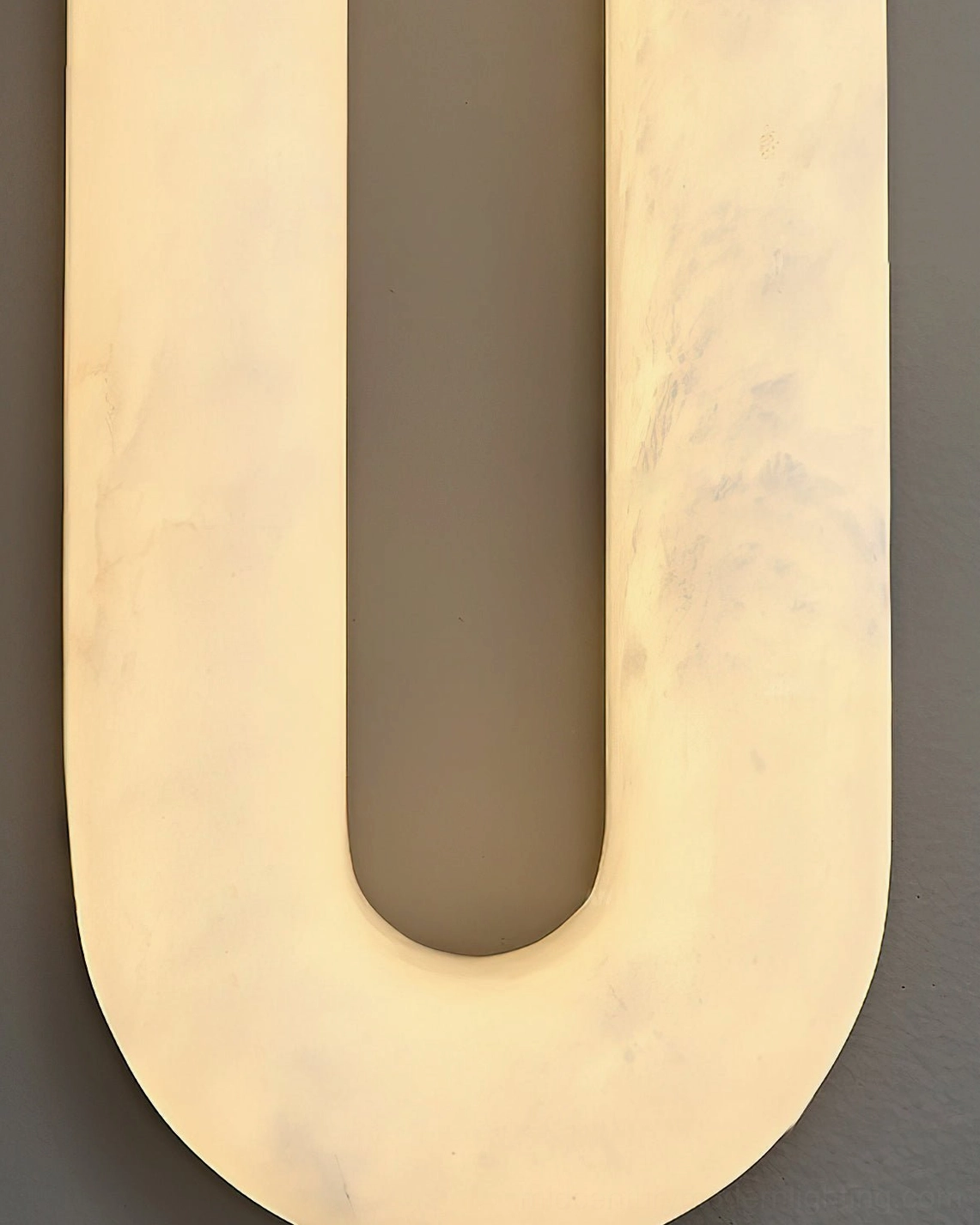 Dromo alabaster wall lamp close-up top-down view, glowing alabaster material with natural stone detail