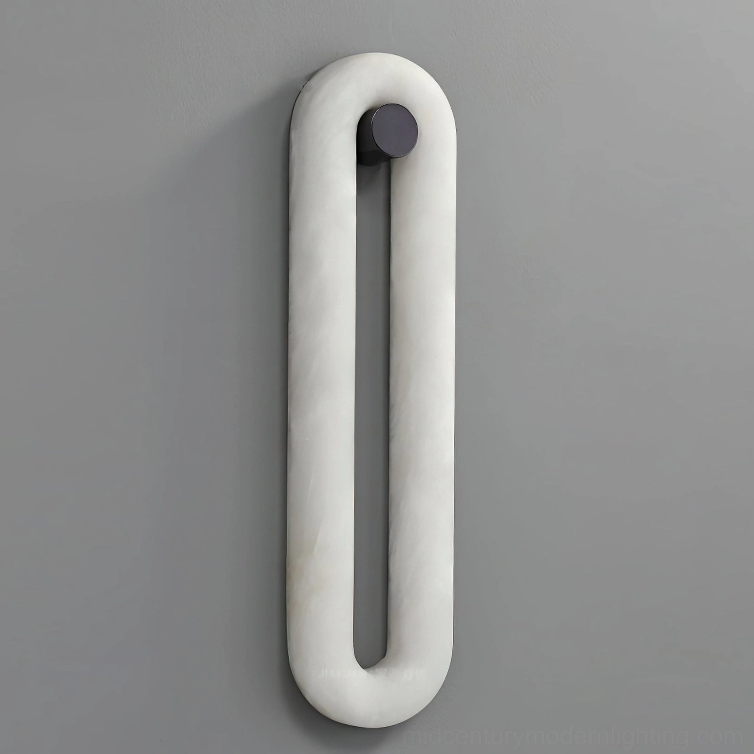Dromo alabaster wall sconce detail view on light gray wall, matte marble finish with black metal base