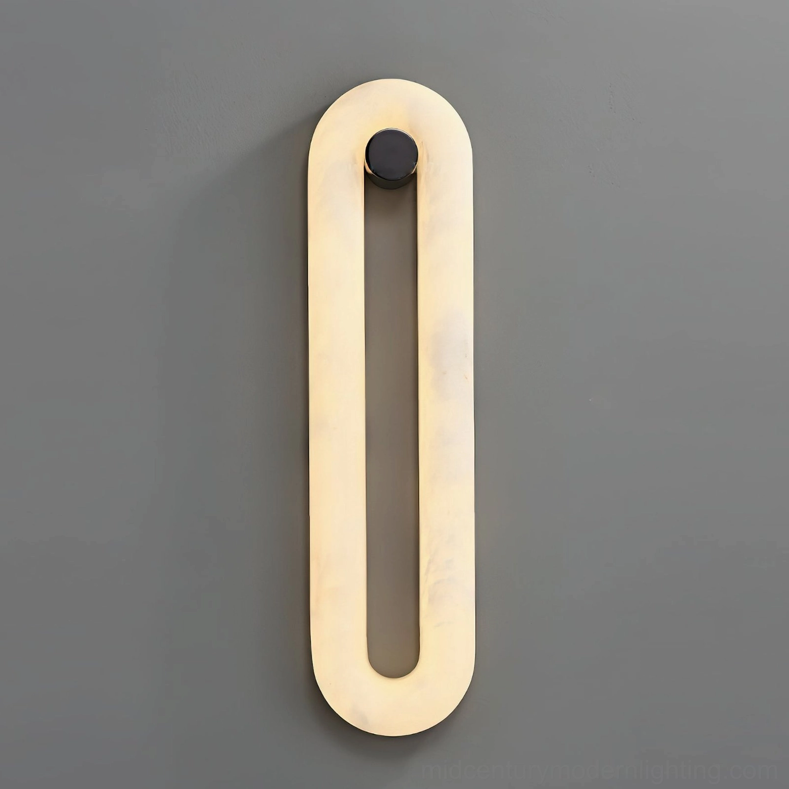 Dromo wall sconce frontal view dark gray backdrop, elongated oval hollow with warm beige glow