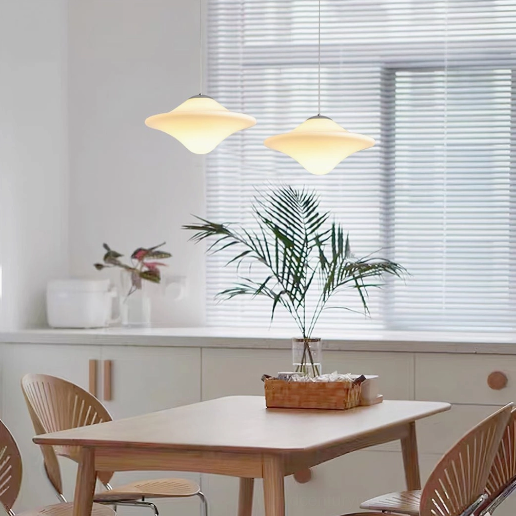 Pair of matching mid-century pendant lamps illuminating kitchen dining space with soft warm glow